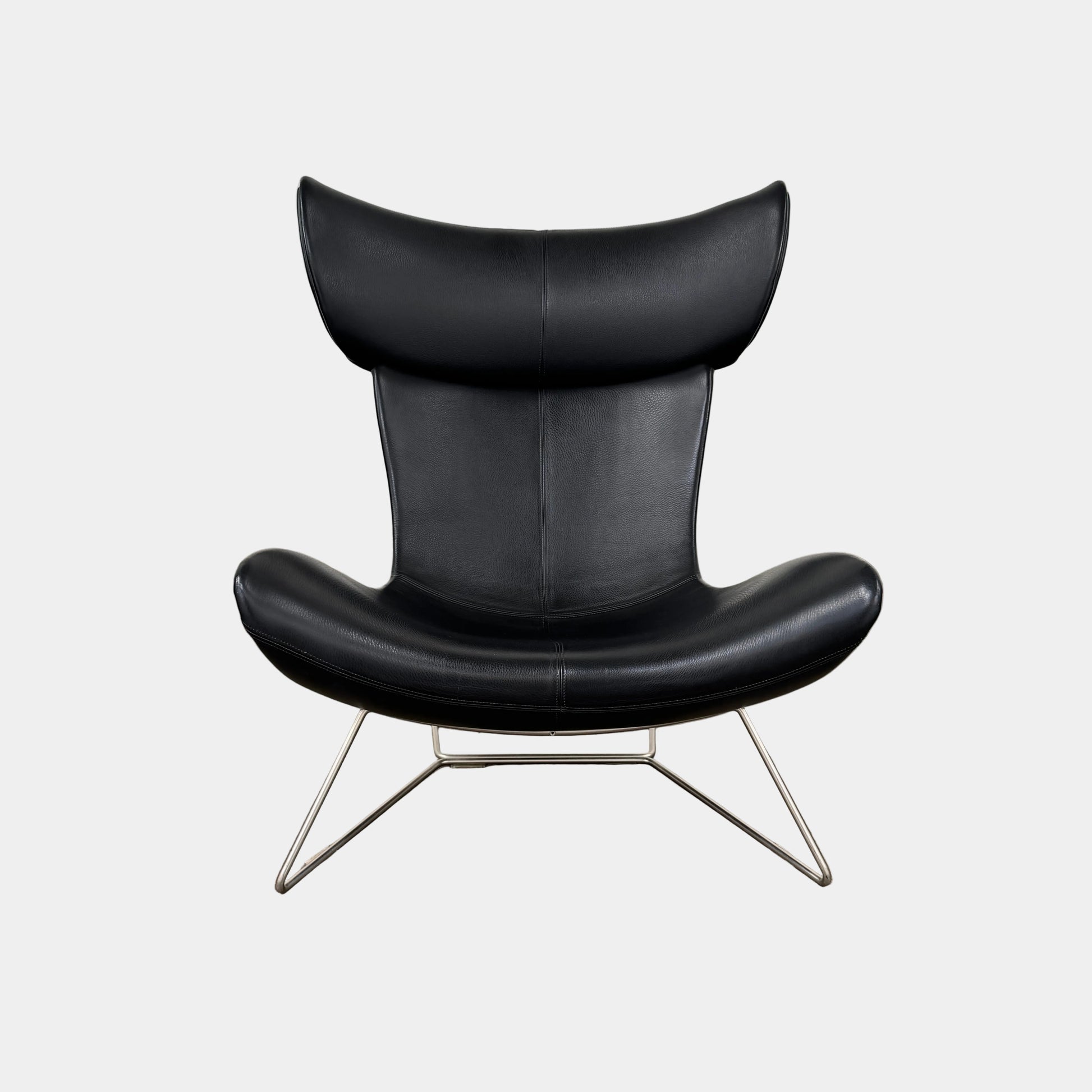 The BoConcept Imola Armchair by BoConcept is a modern black designer lounge chair with a curved leather seat and backrest, supported by slim metal legs, shown against a plain white background—an iconic piece inspired by the original Imola design.