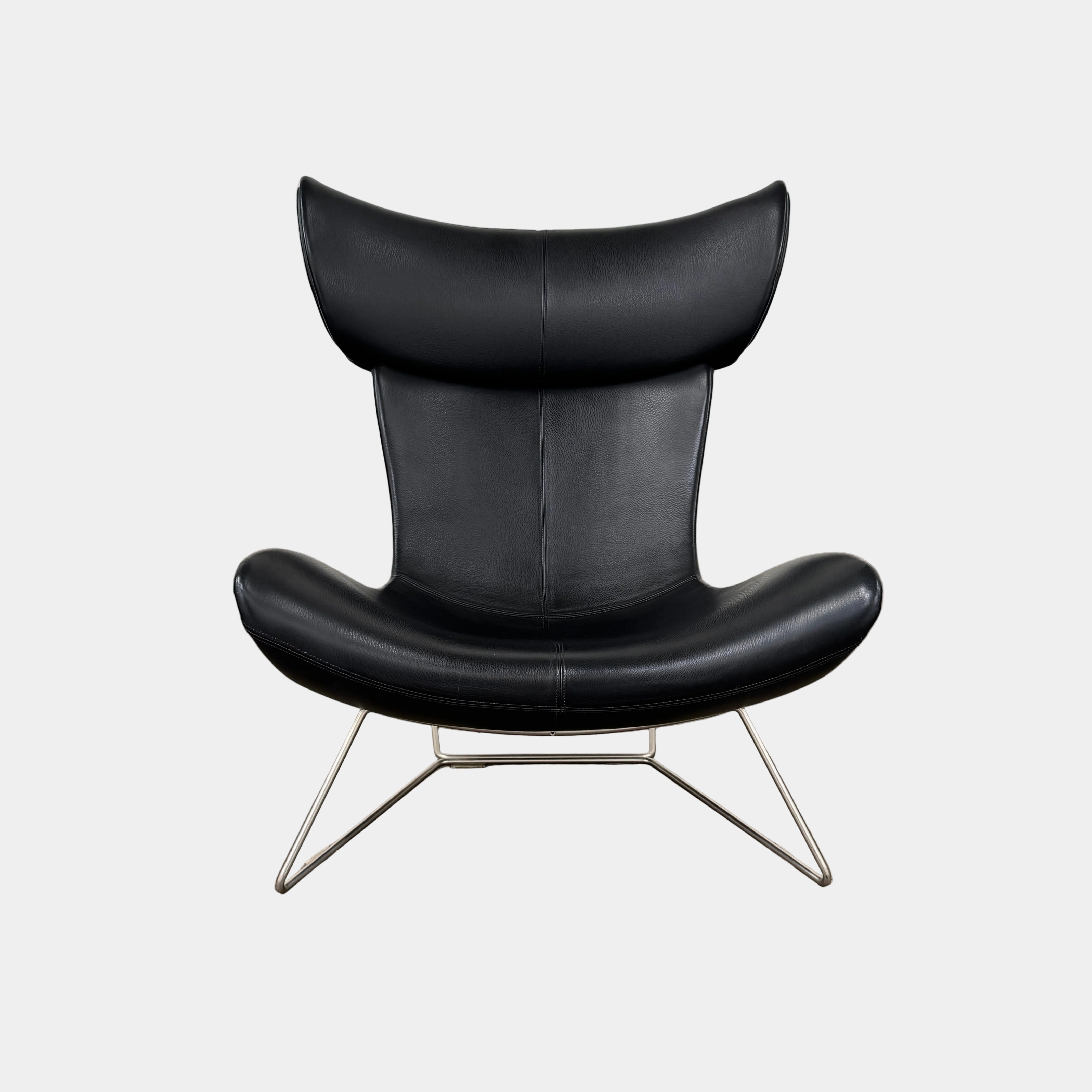 The BoConcept Imola Armchair by BoConcept is a modern black designer lounge chair with a curved leather seat and backrest, supported by slim metal legs, shown against a plain white background—an iconic piece inspired by the original Imola design.