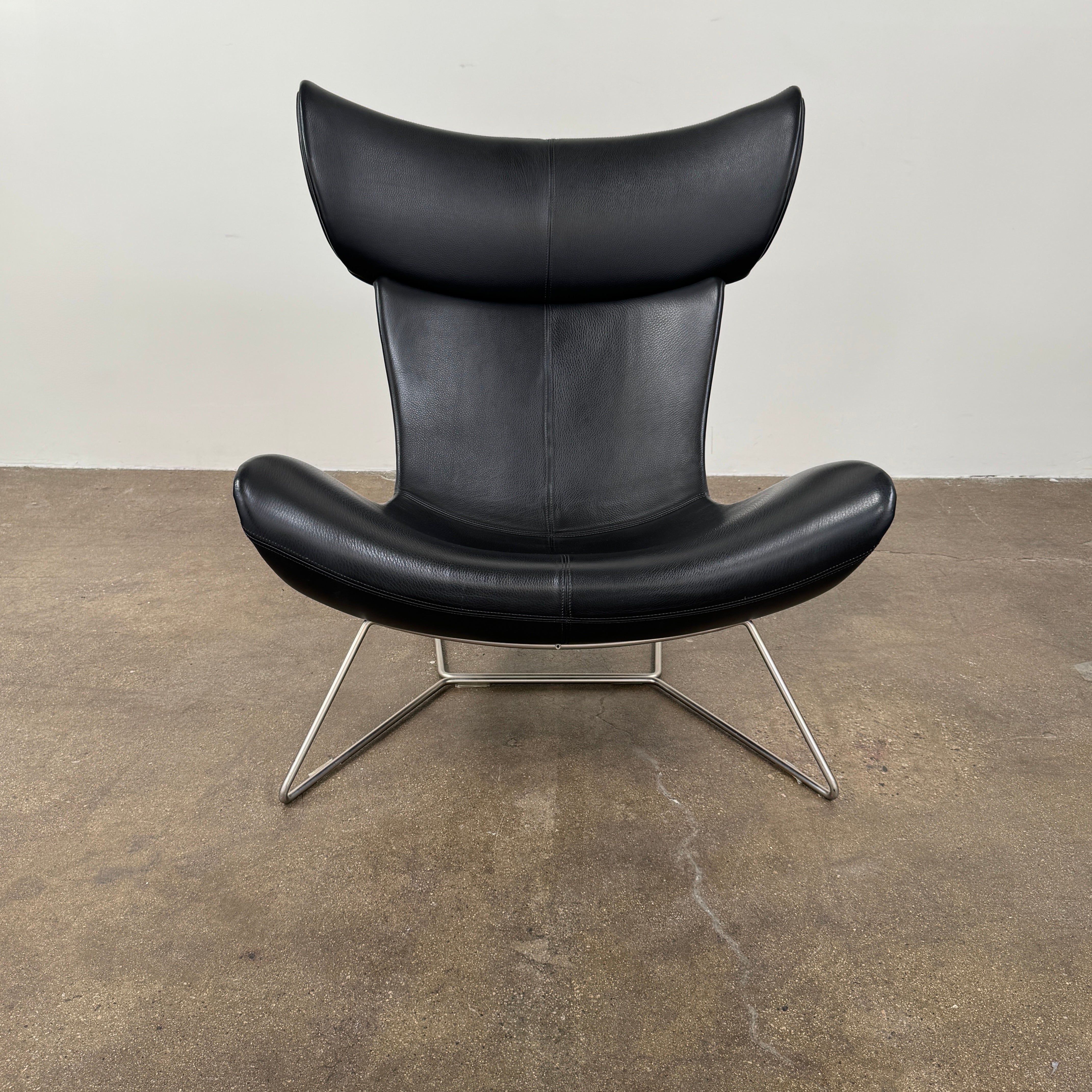 The BoConcept Imola Armchair by BoConcept is a modern black designer lounge chair with a curved leather seat and backrest, supported by slim metal legs, shown against a plain white background—an iconic piece inspired by the original Imola design.