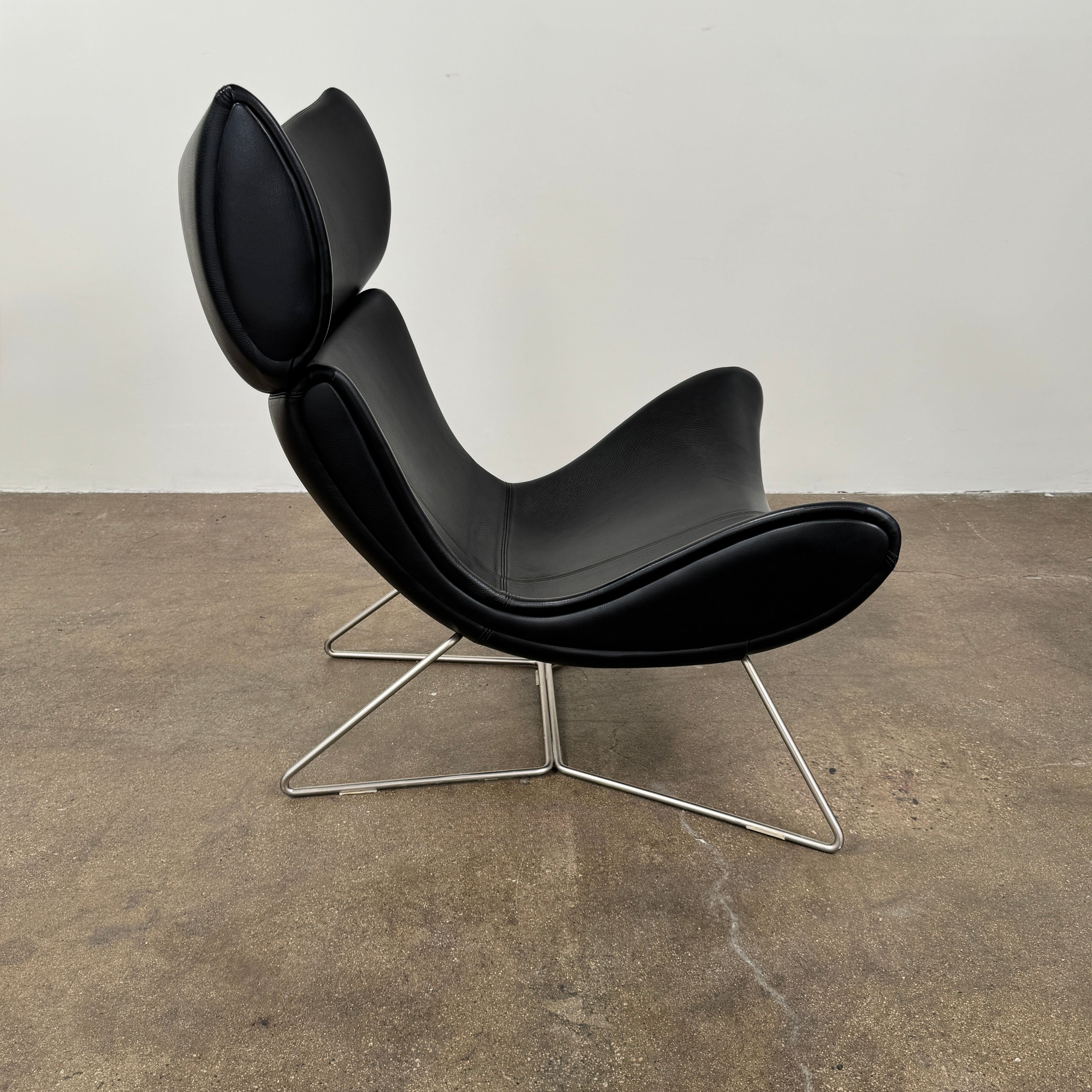 The BoConcept Imola Armchair by BoConcept is a modern black designer lounge chair with a curved leather seat and backrest, supported by slim metal legs, shown against a plain white background—an iconic piece inspired by the original Imola design.