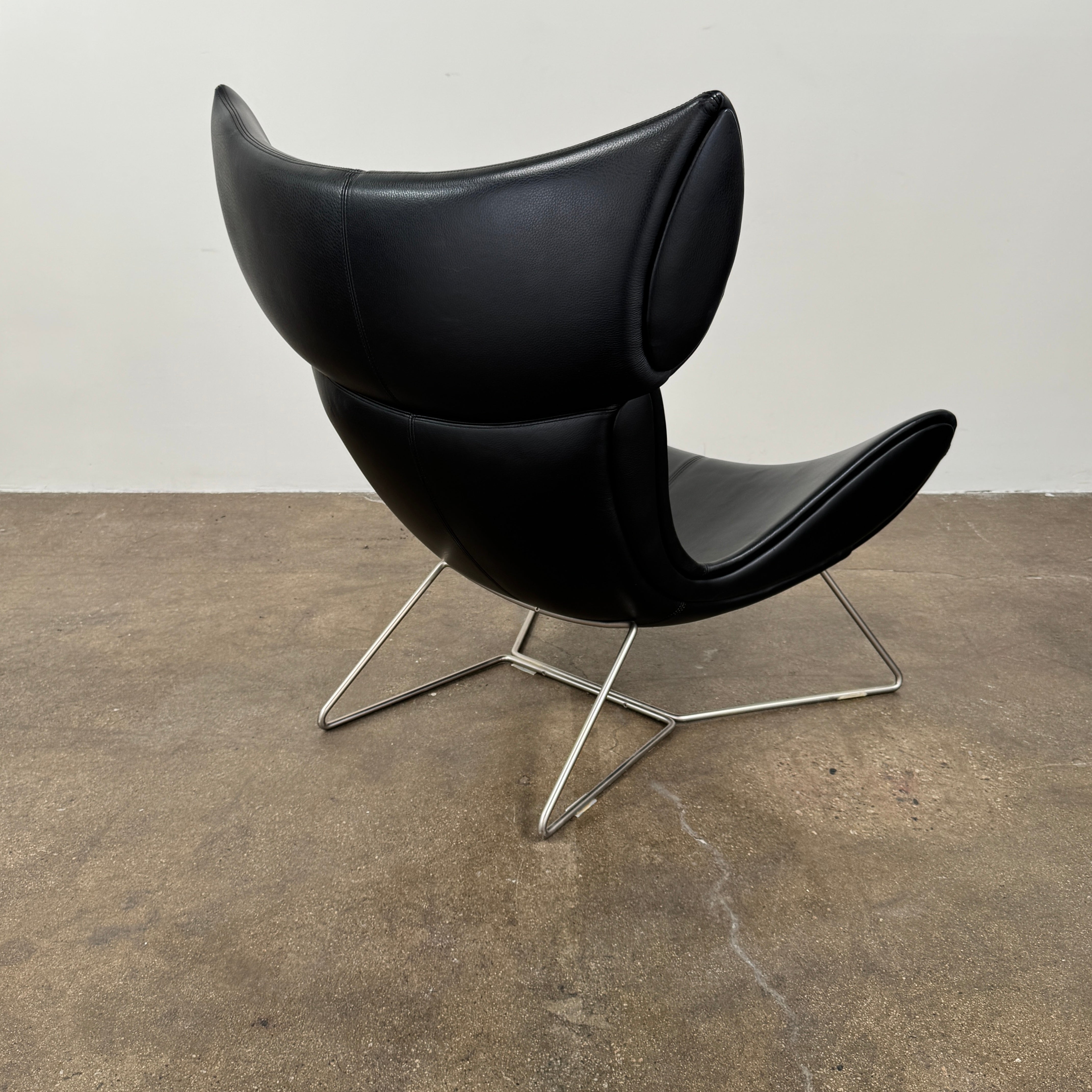 The BoConcept Imola Armchair by BoConcept is a modern black designer lounge chair with a curved leather seat and backrest, supported by slim metal legs, shown against a plain white background—an iconic piece inspired by the original Imola design.