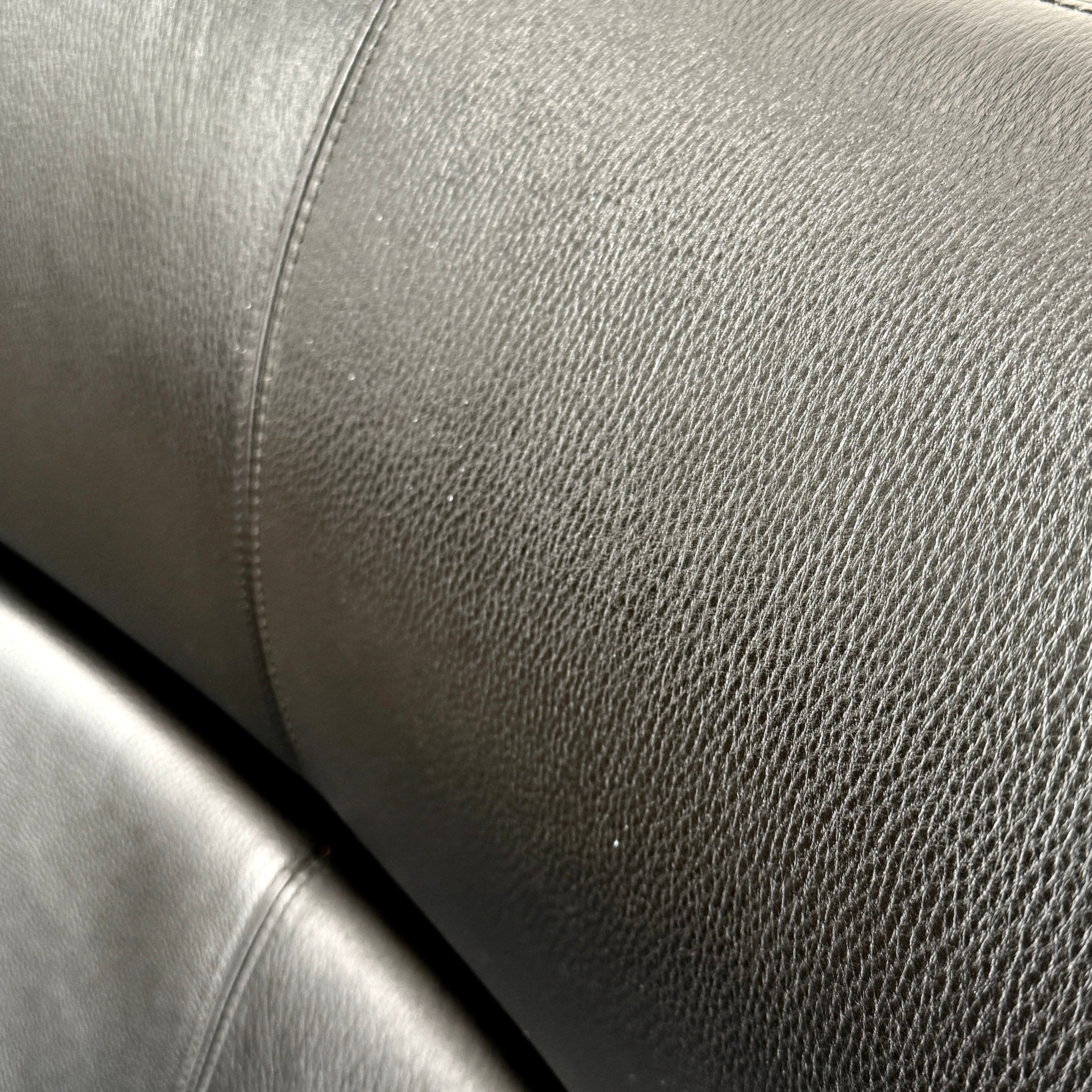 The BoConcept Imola Armchair by BoConcept is a modern black designer lounge chair with a curved leather seat and backrest, supported by slim metal legs, shown against a plain white background—an iconic piece inspired by the original Imola design.
