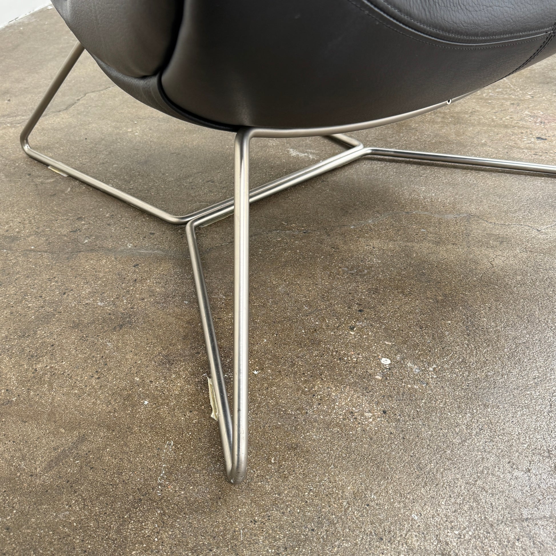 The BoConcept Imola Armchair by BoConcept is a modern black designer lounge chair with a curved leather seat and backrest, supported by slim metal legs, shown against a plain white background—an iconic piece inspired by the original Imola design.