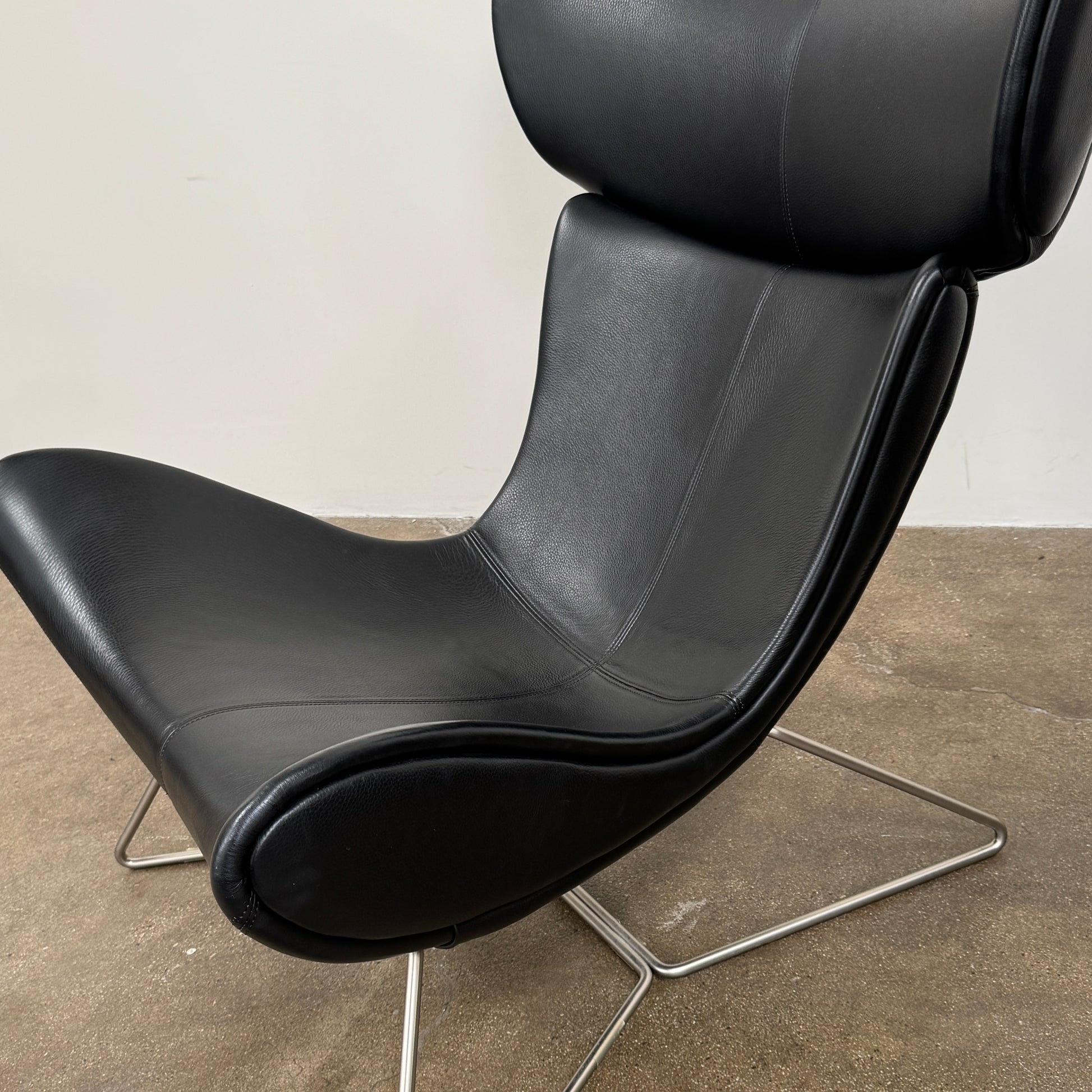 The BoConcept Imola Armchair by BoConcept is a modern black designer lounge chair with a curved leather seat and backrest, supported by slim metal legs, shown against a plain white background—an iconic piece inspired by the original Imola design.