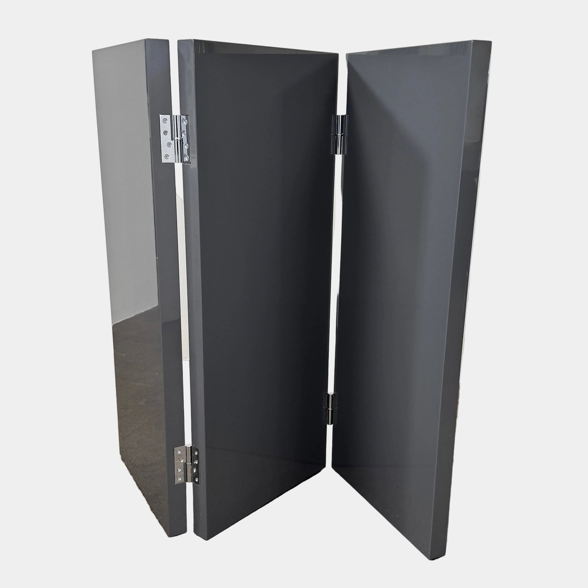 Three large, glossy black rectangular panels connected by metal hinges stand partially folded on a plain background, showcasing the refined sophistication of the Maxalto Arkè 3 Panel Screen by Maxalto—a striking room divider that brings elegant style to any interior.