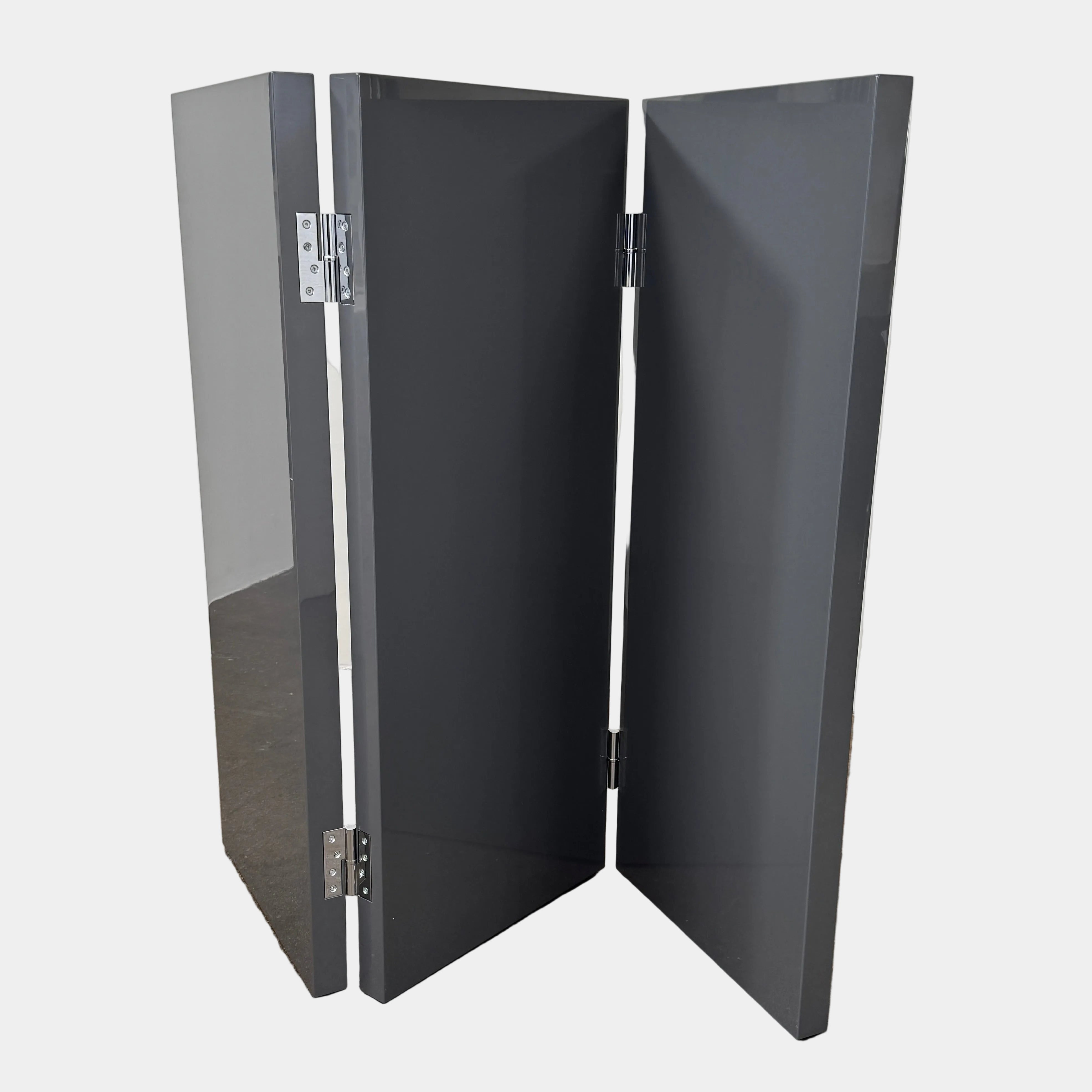 Three large, glossy black rectangular panels connected by metal hinges stand partially folded on a plain background, showcasing the refined sophistication of the Maxalto Arkè 3 Panel Screen by Maxalto—a striking room divider that brings elegant style to any interior.