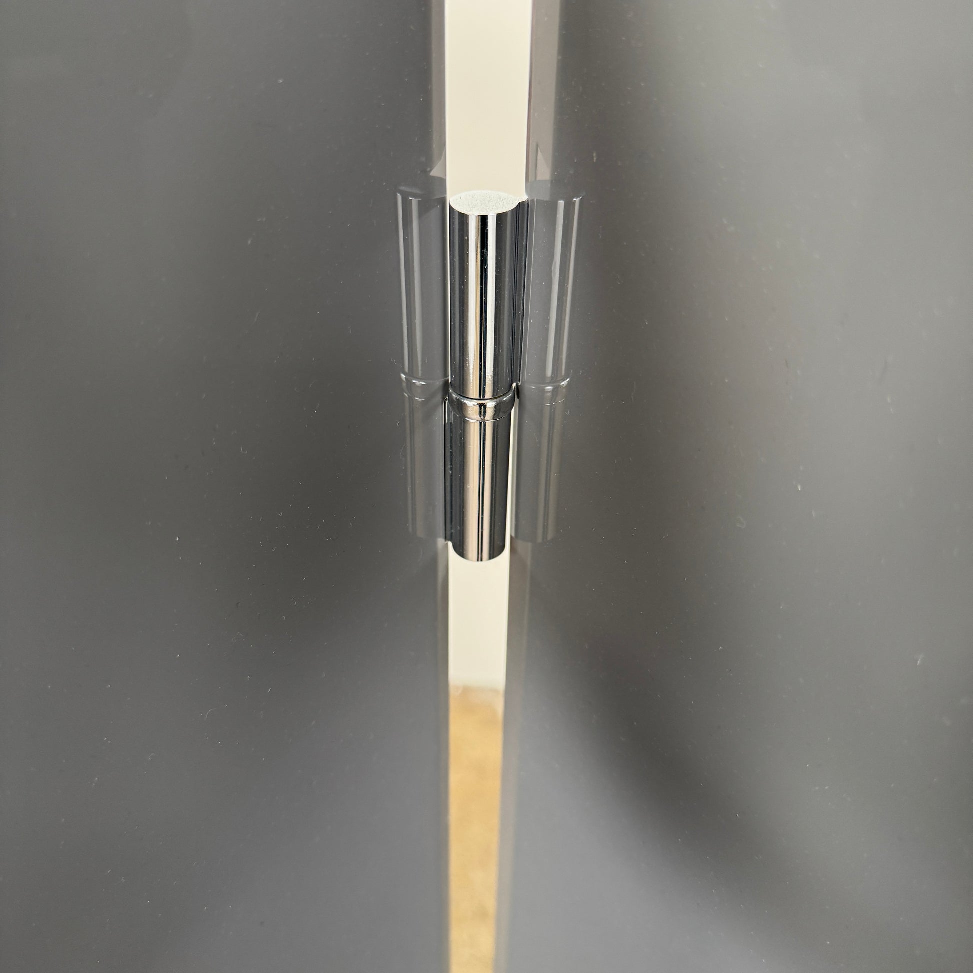Three large, glossy black rectangular panels connected by metal hinges stand partially folded on a plain background, showcasing the refined sophistication of the Maxalto Arkè 3 Panel Screen by Maxalto—a striking room divider that brings elegant style to any interior.