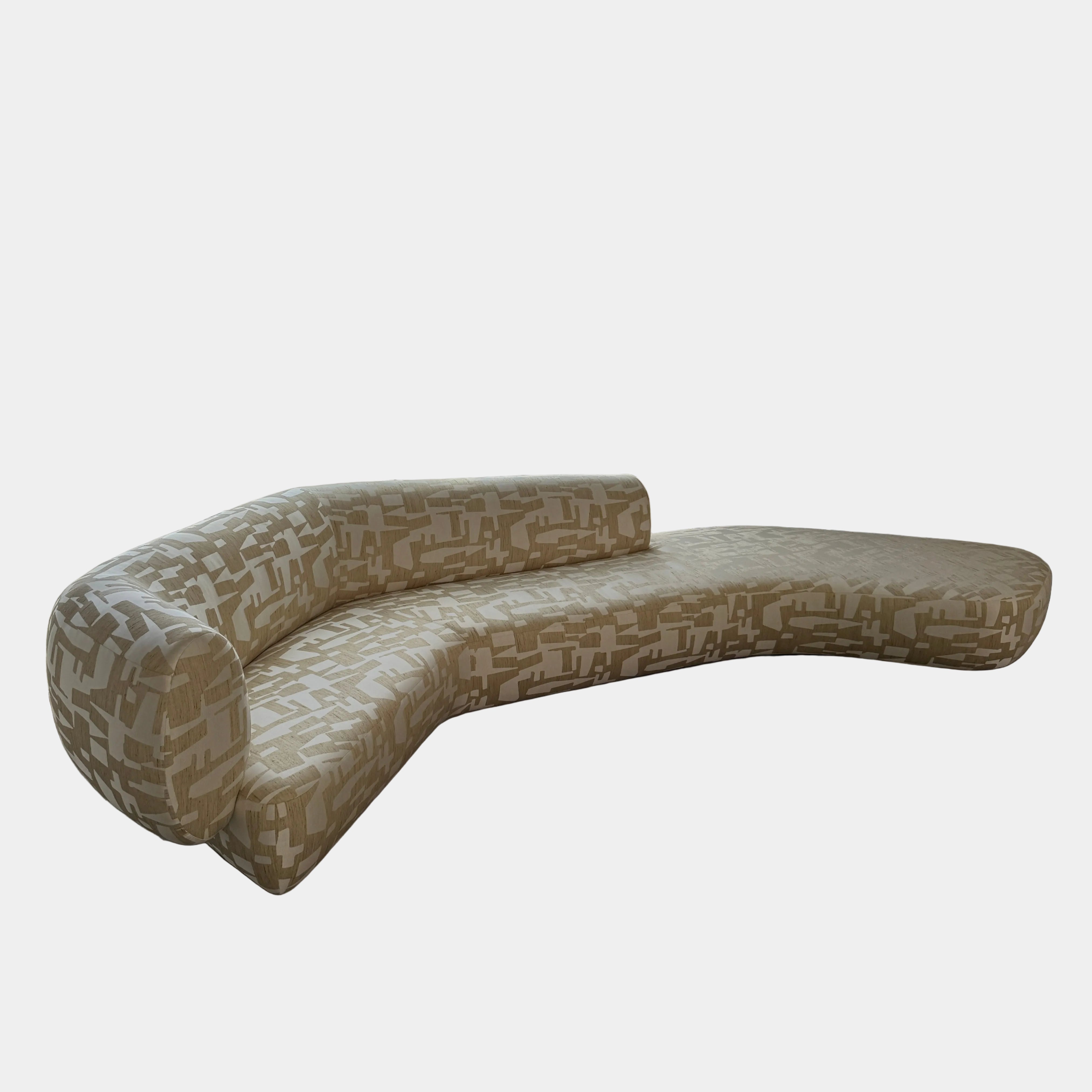 The Muskoka Living Custom Sofa by Muskoka Living showcases an asymmetrical contemporary silhouette with a low backrest, upholstered in luxurious Italian jacquard fabric featuring an abstract geometric pattern in beige, and is presented against a plain white background.