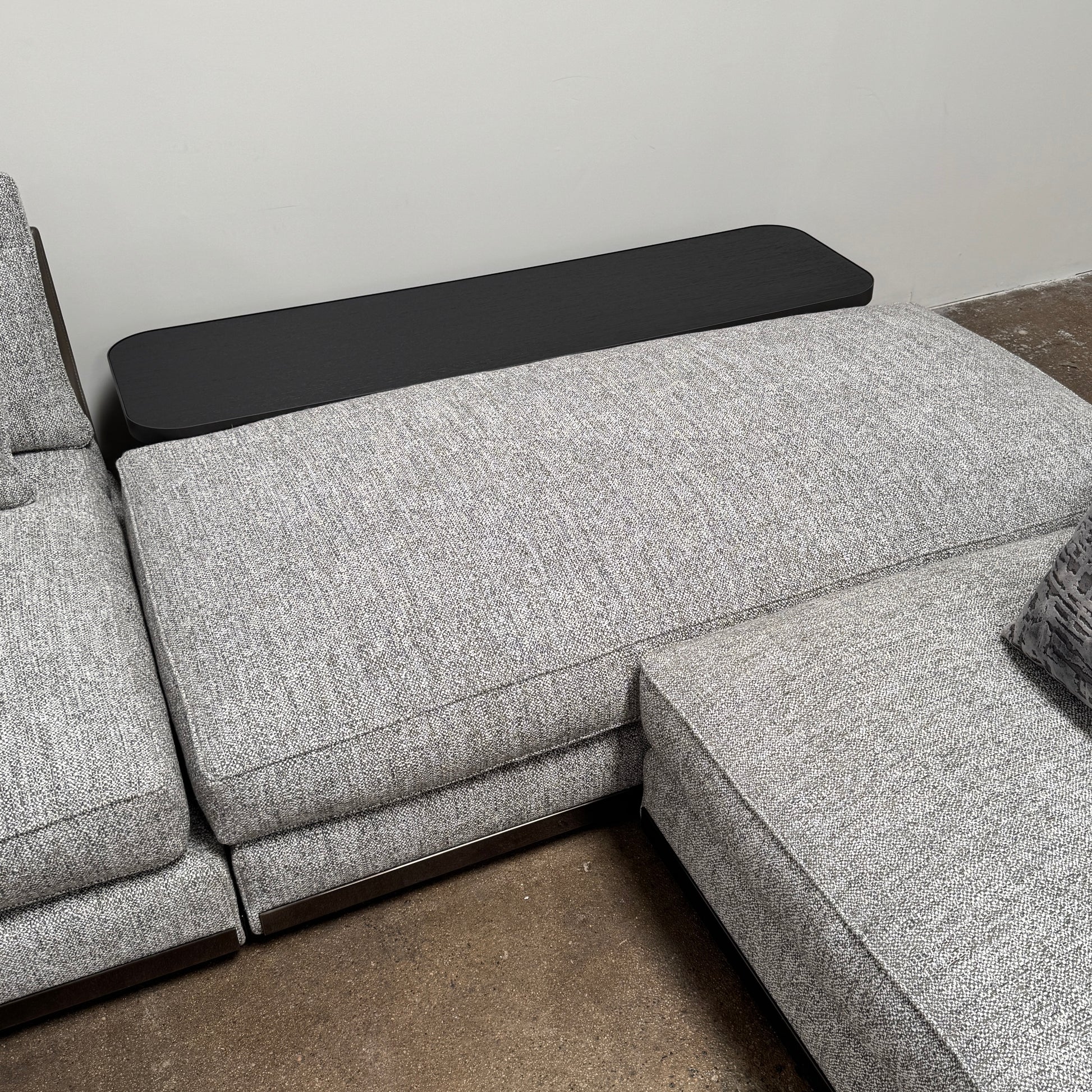 The Minotti West Sectional Sofa with Side Table and Clive Bench by Minotti features a large, L-shaped modern design with gray upholstery, multiple plush cushions, and an integrated side table—perfect for elevating luxury living rooms—all set against a plain white background.