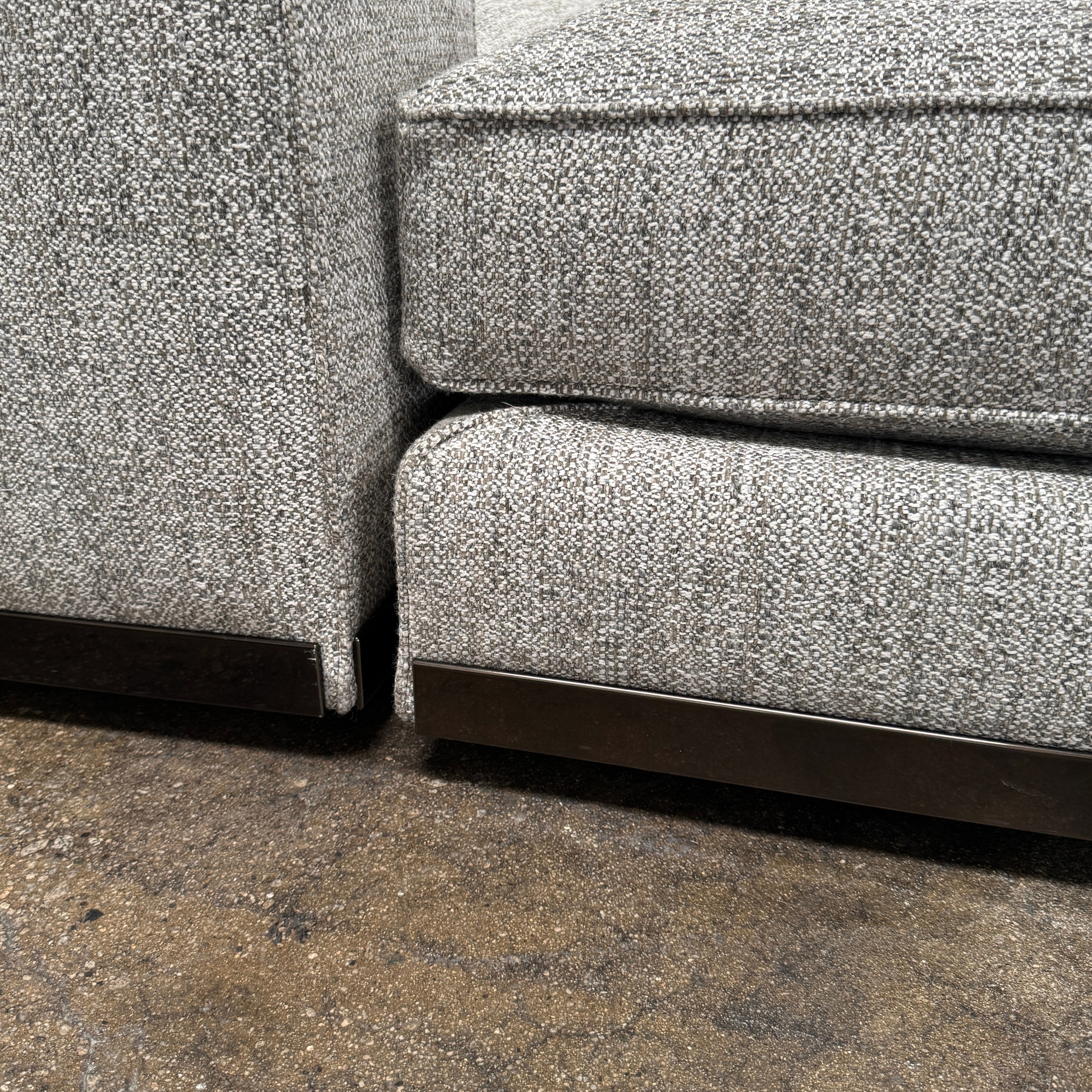 The Minotti West Sectional Sofa with Side Table and Clive Bench by Minotti features a large, L-shaped modern design with gray upholstery, multiple plush cushions, and an integrated side table—perfect for elevating luxury living rooms—all set against a plain white background.