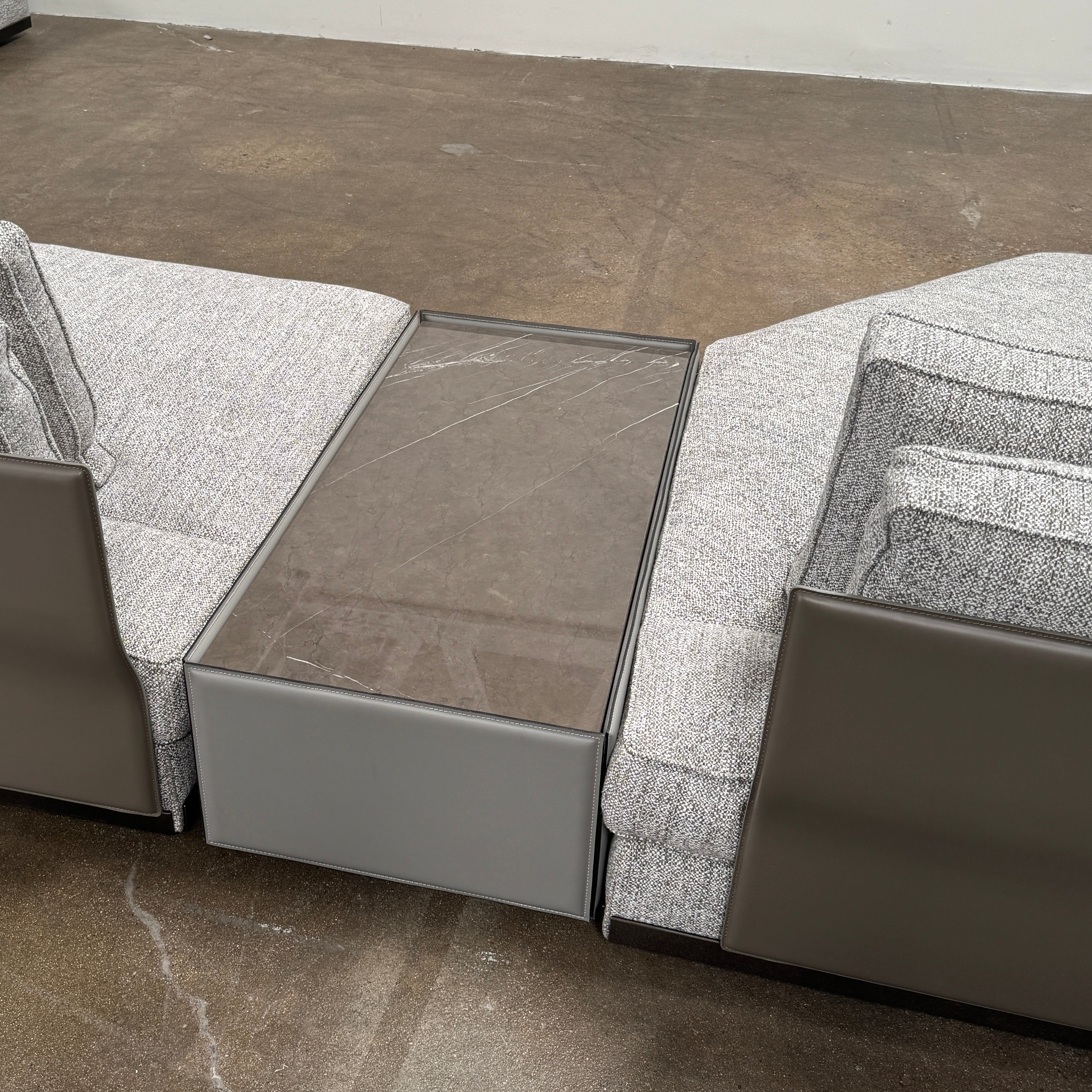 The Minotti West Sectional Sofa with Side Table and Clive Bench by Minotti features a large, L-shaped modern design with gray upholstery, multiple plush cushions, and an integrated side table—perfect for elevating luxury living rooms—all set against a plain white background.