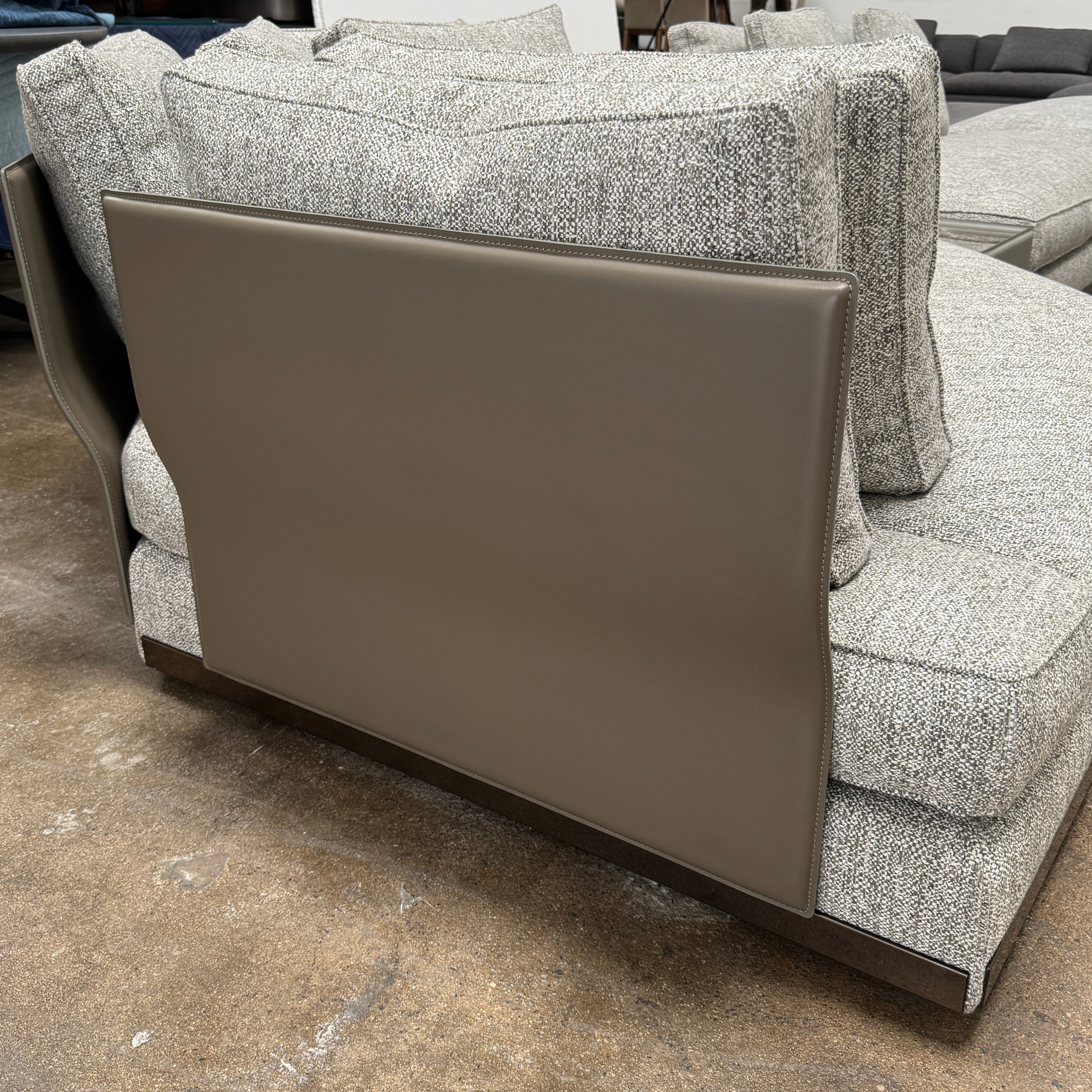 The Minotti West Sectional Sofa with Side Table and Clive Bench by Minotti features a large, L-shaped modern design with gray upholstery, multiple plush cushions, and an integrated side table—perfect for elevating luxury living rooms—all set against a plain white background.