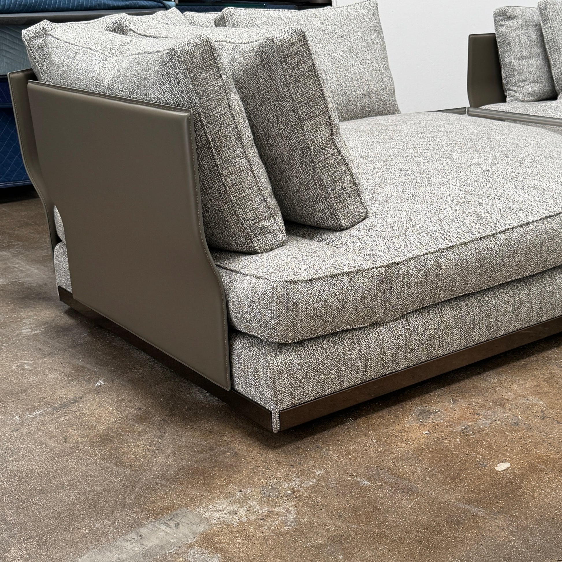 The Minotti West Sectional Sofa with Side Table and Clive Bench by Minotti features a large, L-shaped modern design with gray upholstery, multiple plush cushions, and an integrated side table—perfect for elevating luxury living rooms—all set against a plain white background.