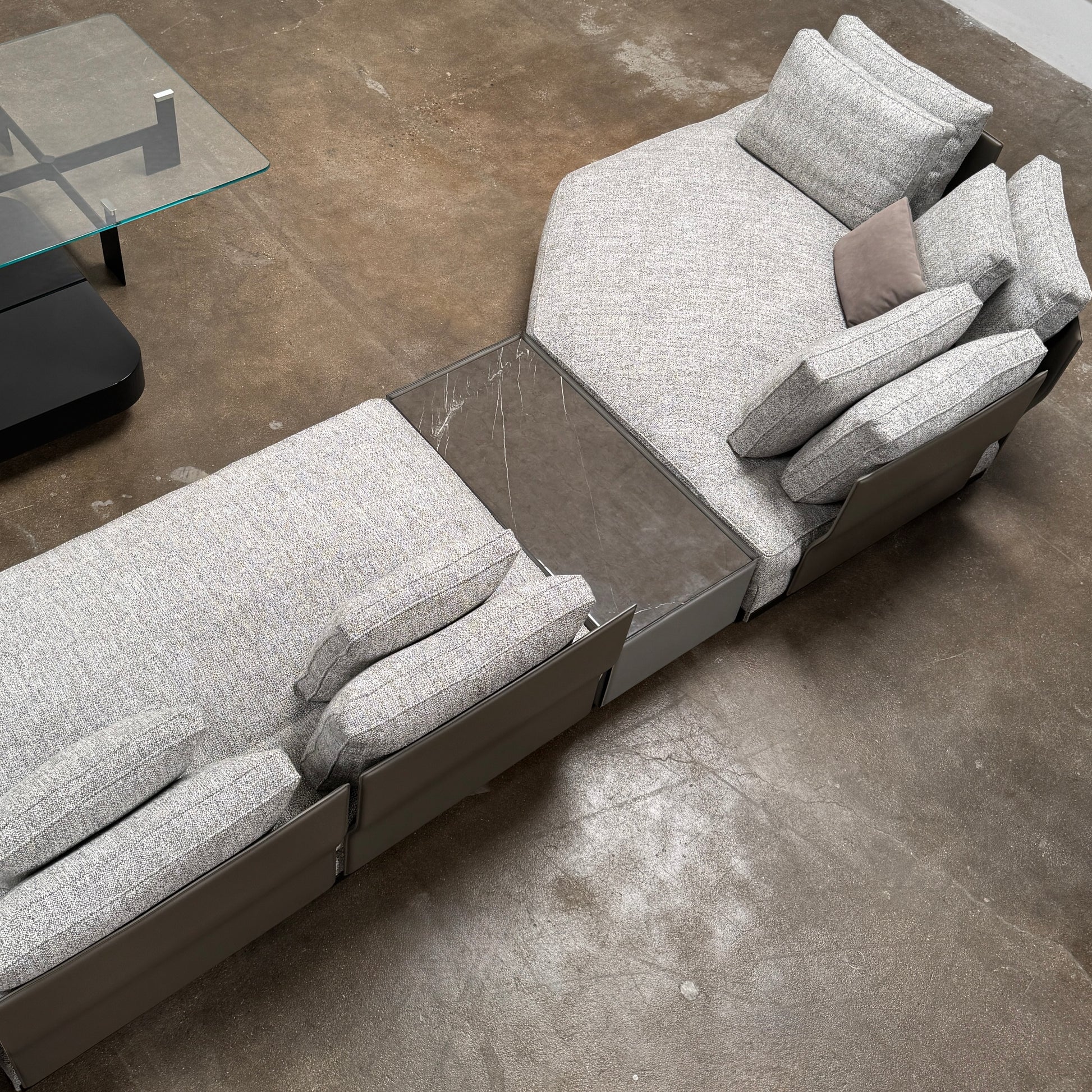 The Minotti West Sectional Sofa with Side Table and Clive Bench by Minotti features a large, L-shaped modern design with gray upholstery, multiple plush cushions, and an integrated side table—perfect for elevating luxury living rooms—all set against a plain white background.