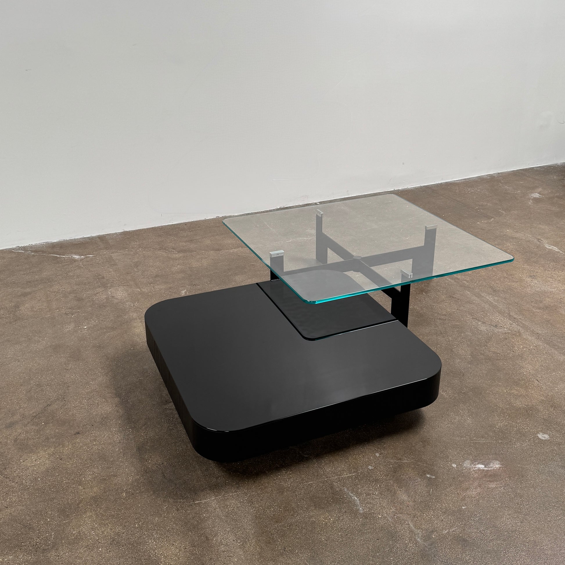 The Minotti Milton + Ellis Coffee Table Set by Minotti features a contemporary design with a black rectangular base and an attached elevated glass top supported by sleek metal brackets, presented against a plain white background.