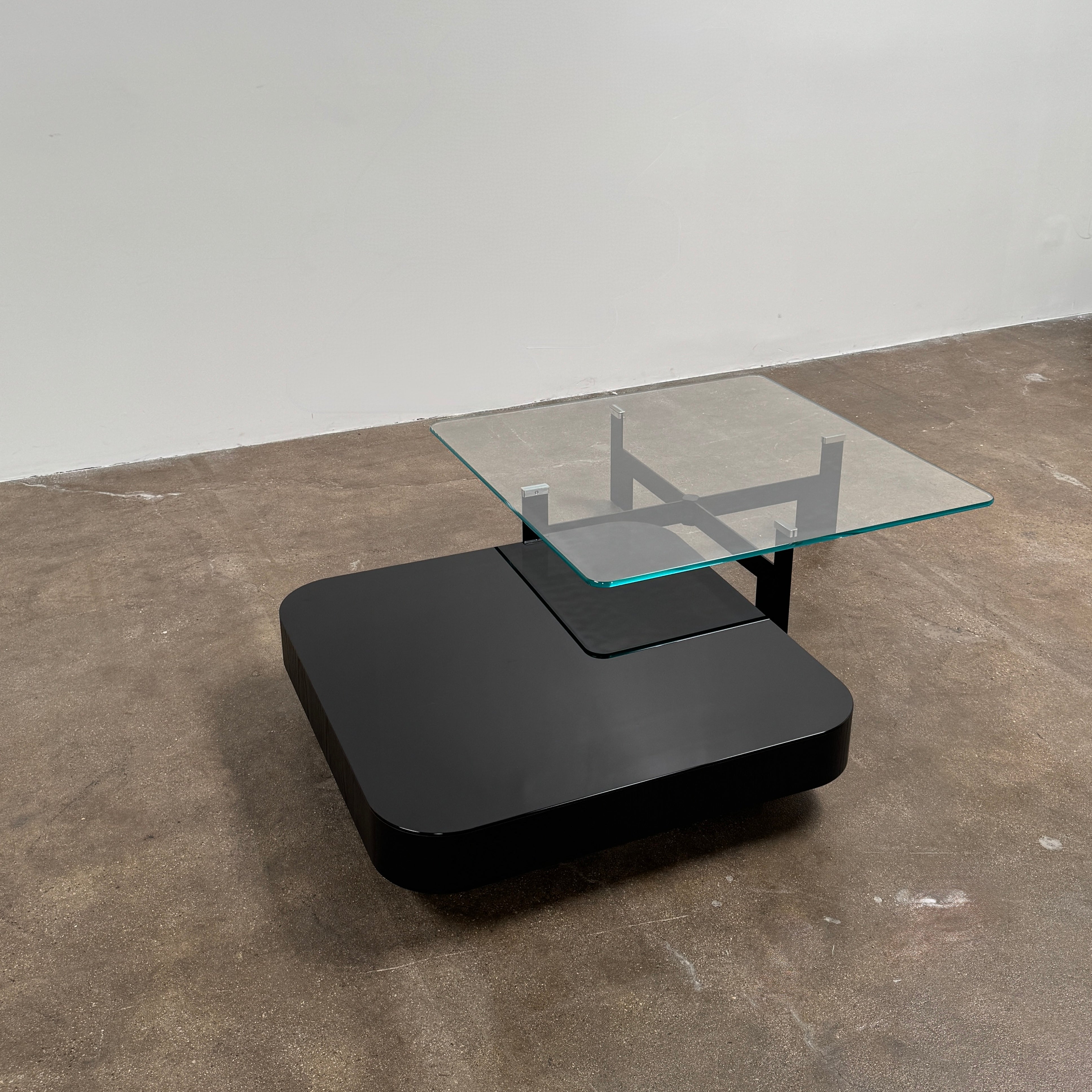 The Minotti Milton + Ellis Coffee Table Set by Minotti features a contemporary design with a black rectangular base and an attached elevated glass top supported by sleek metal brackets, presented against a plain white background.