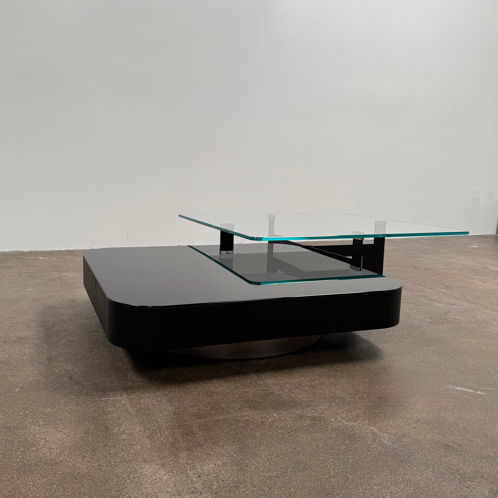 The Minotti Milton + Ellis Coffee Table Set by Minotti features a contemporary design with a black rectangular base and an attached elevated glass top supported by sleek metal brackets, presented against a plain white background.