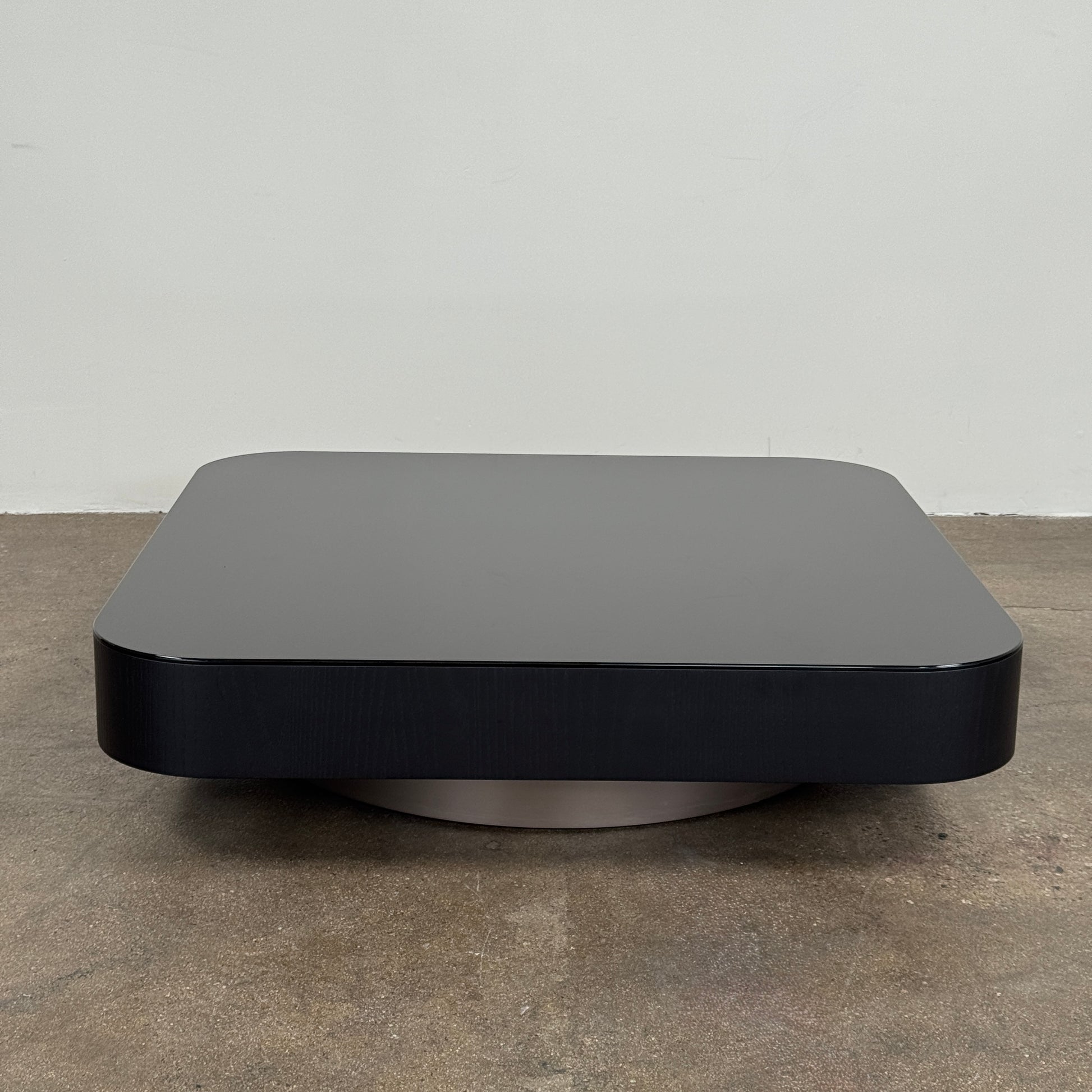 The Minotti Milton + Ellis Coffee Table Set by Minotti features a contemporary design with a black rectangular base and an attached elevated glass top supported by sleek metal brackets, presented against a plain white background.