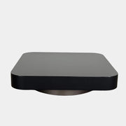 The Minotti Milton Coffee Table by Minotti, featuring a low, square silhouette with rounded corners and a flat surface, stands against a plain white background and embodies contemporary design with an understated sculptural elegance.