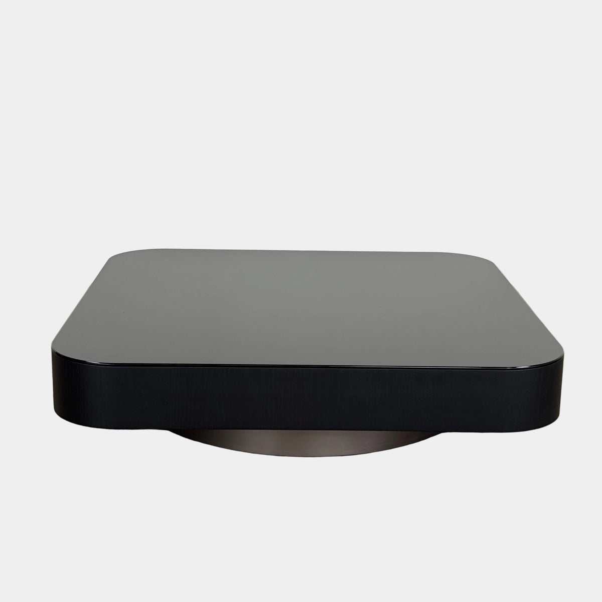 The Minotti Milton Coffee Table by Minotti, featuring a low, square silhouette with rounded corners and a flat surface, stands against a plain white background and embodies contemporary design with an understated sculptural elegance.