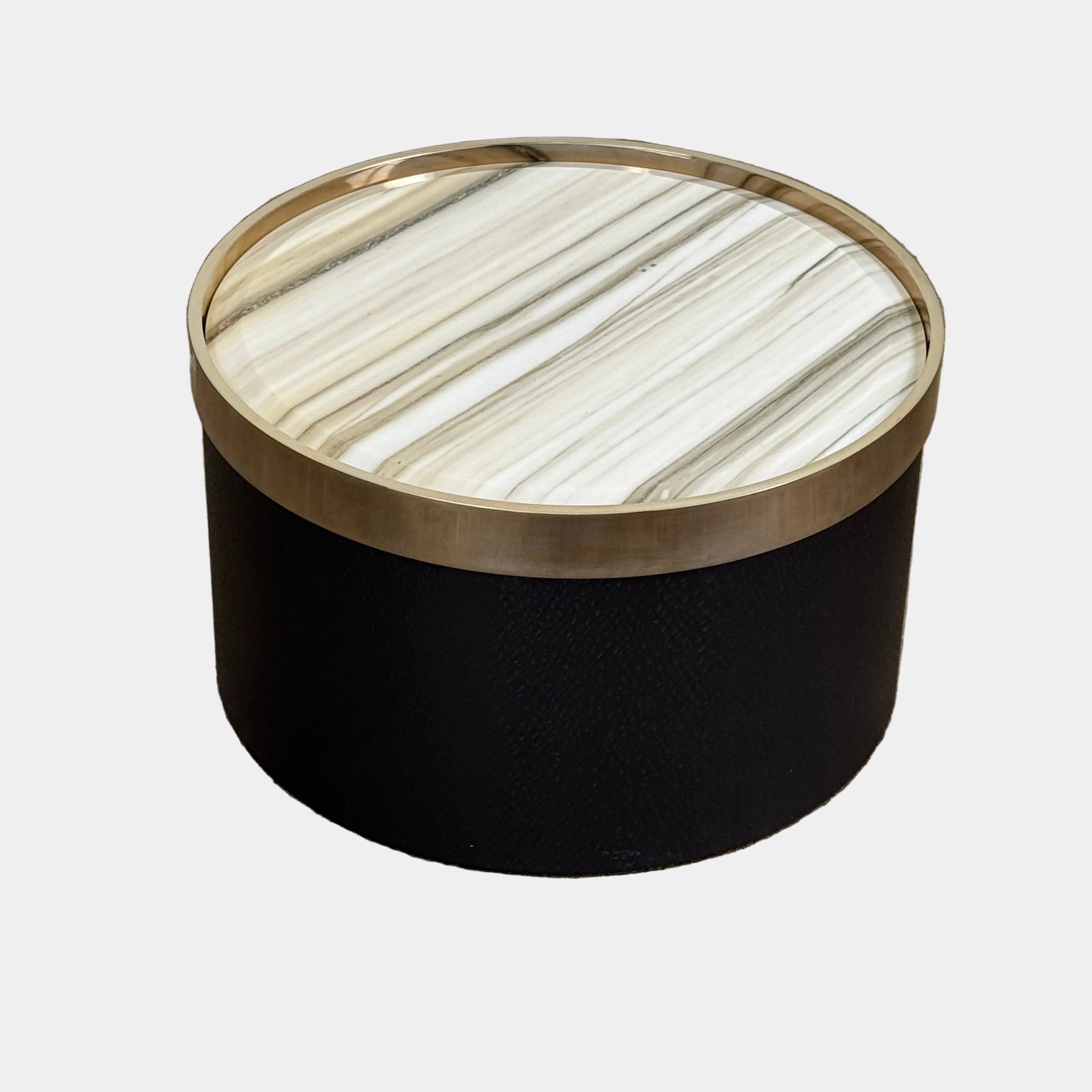A round luxury accent table from Minotti, the Bally Accent Table features a black cylindrical base and a light-colored, striped marble top encircled by a slim metallic rim, elegantly displayed on a textured brown floor. Inspired by refined design, this signature piece from Minotti makes an essential addition to any luxury furniture collection.