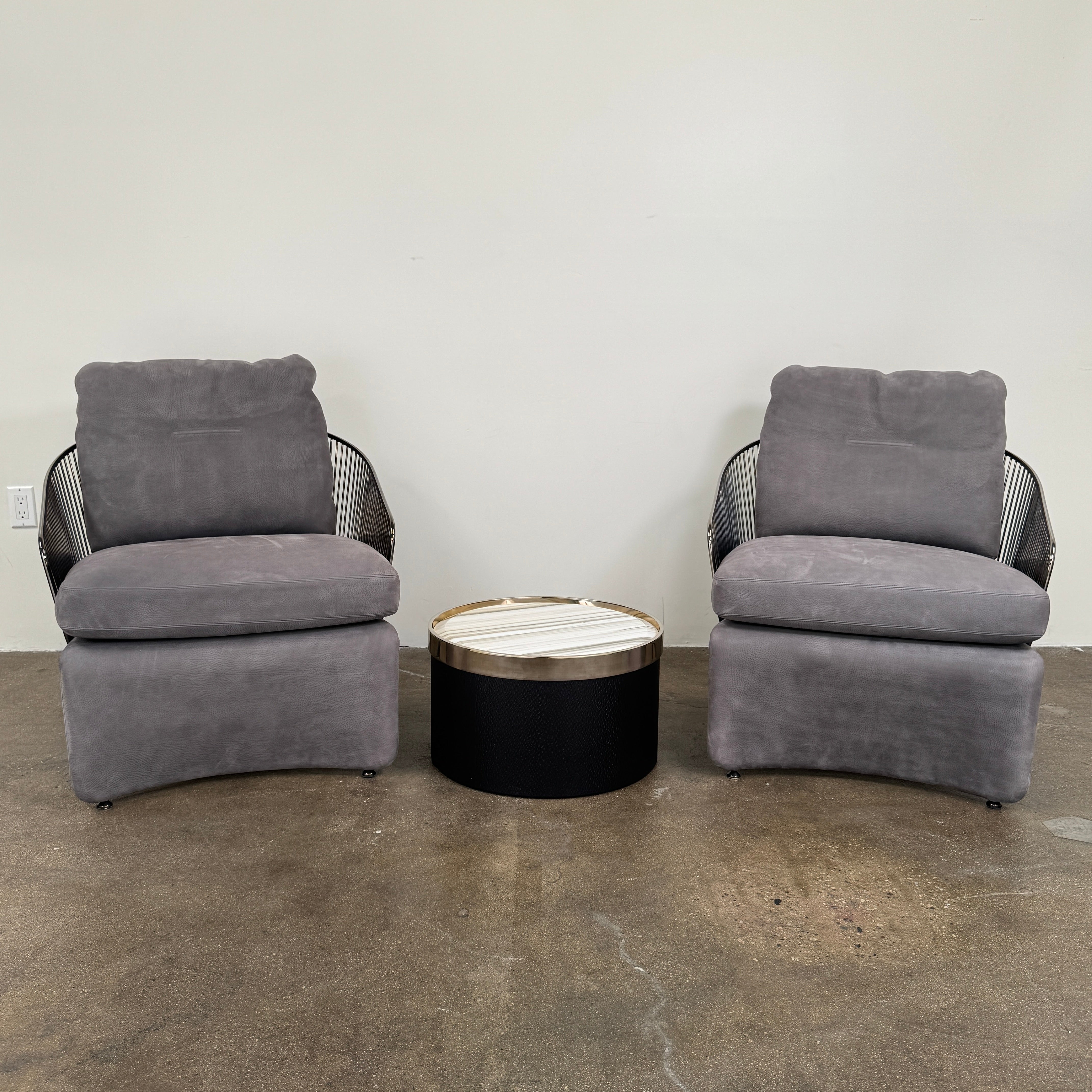 Minotti Bally Side Table Marble by Modern Resale with a black base and a polished marble top featuring light and dark horizontal stripes, set on a brown textured floor beside a sleek rectangular planter.