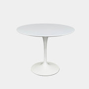 The Knoll Saarinen Dining Table 35" Round by Knoll, featuring a sleek white finish and iconic single pedestal base inspired by the classic Tulip design, is displayed against a plain white background.