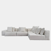 The Living Divani NeoWall 4 piece Modular Sofa by Living Divani is a modern, light beige Italian modular sofa featuring six large seat cushions and seven matching throw pillows, displayed against a white background.