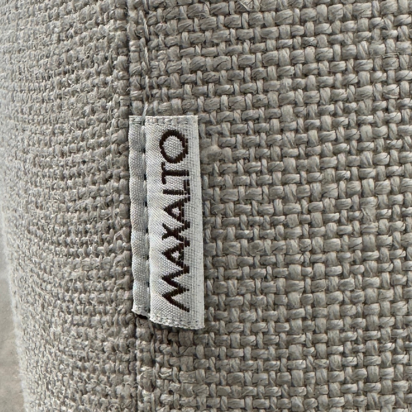 A modern Maxalto Lucrezia Soft Armchair in light gray, featuring square arms, a cushioned seat and back, and dark wooden legs from Maxalto, showcases refined design and plush comfort against a plain white background.