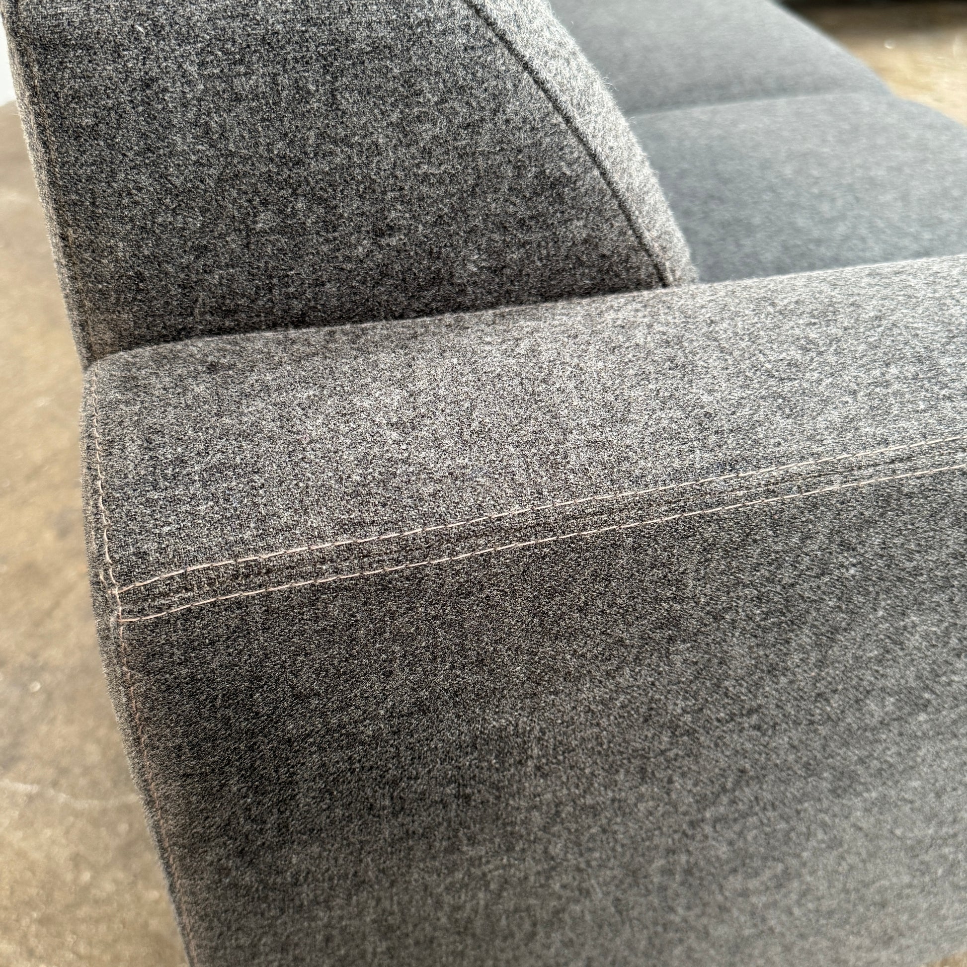 The Artifort More Mare Sectional by Artifort is a modern, dark gray sectional sofa featuring a minimalist metal frame and luxurious gray wool upholstery inspired by René Holten’s design, set against a plain white background.