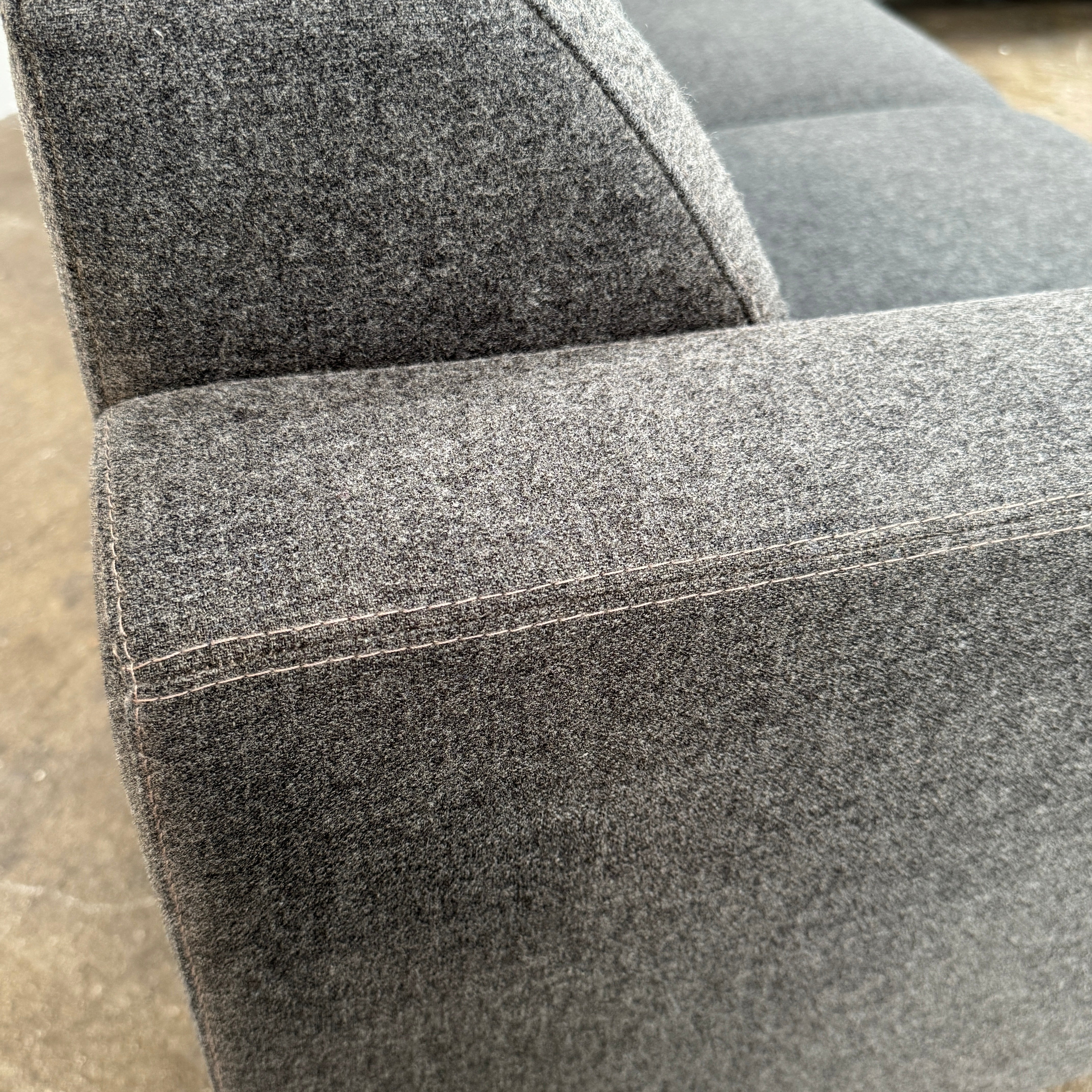 The Artifort More Mare Sectional by Artifort is a modern, dark gray sectional sofa featuring a minimalist metal frame and luxurious gray wool upholstery inspired by René Holten’s design, set against a plain white background.