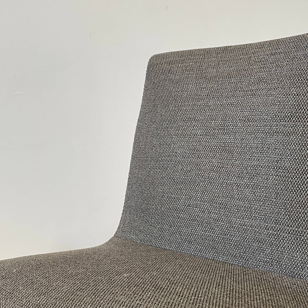 A comfortable Ligne Roset TV Chair with a classic design, featuring gray upholstery and black legs, set against a white background.