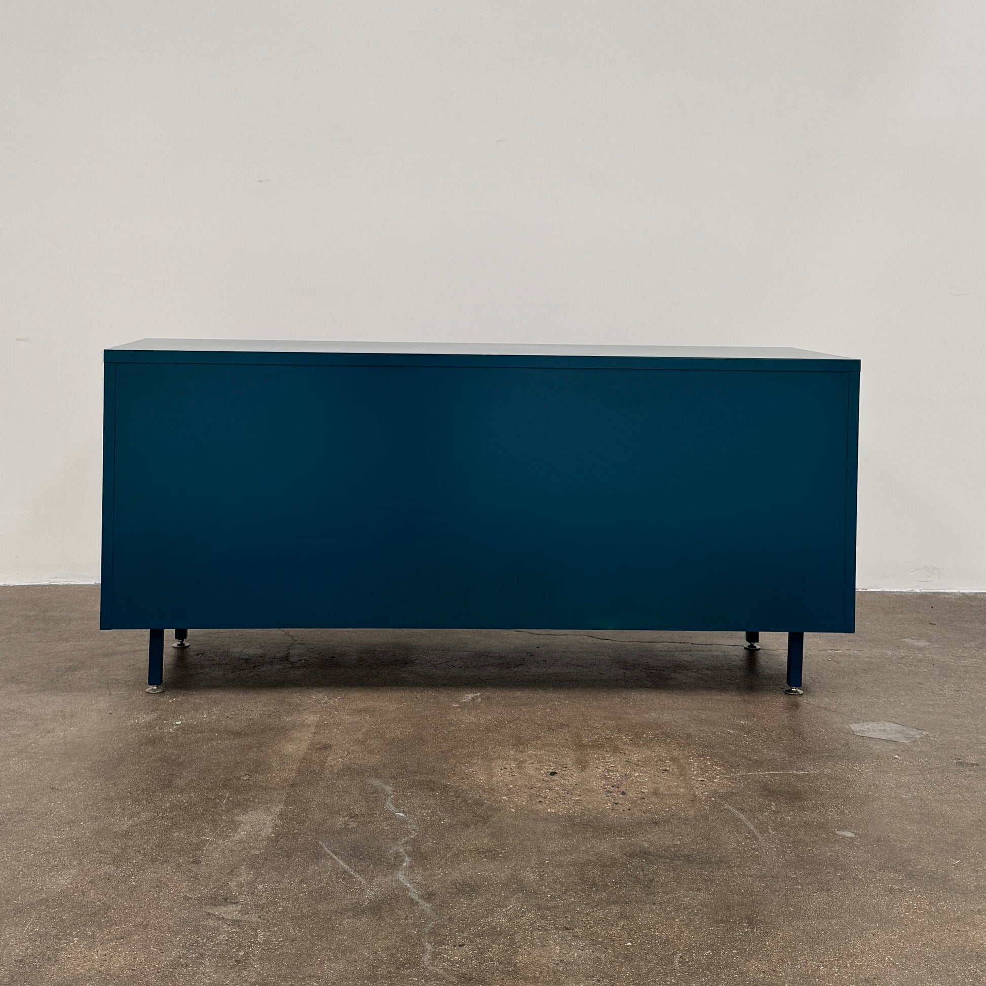 A blue metal Heartwork Active Duty Storage Credenza with two doors, a central lock, and four legs stands against a plain white background—this Heartwork piece offers durable construction ideal for workplace storage.