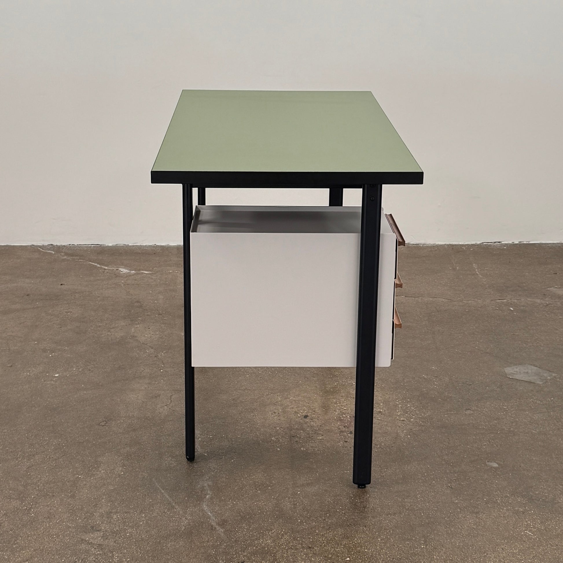 The Herman Miller Mode Desk by Herman Miller features a rectangular green tabletop, black legs, and three white drawers mounted underneath the left side—perfect as a compact desk for a minimalist workspace.