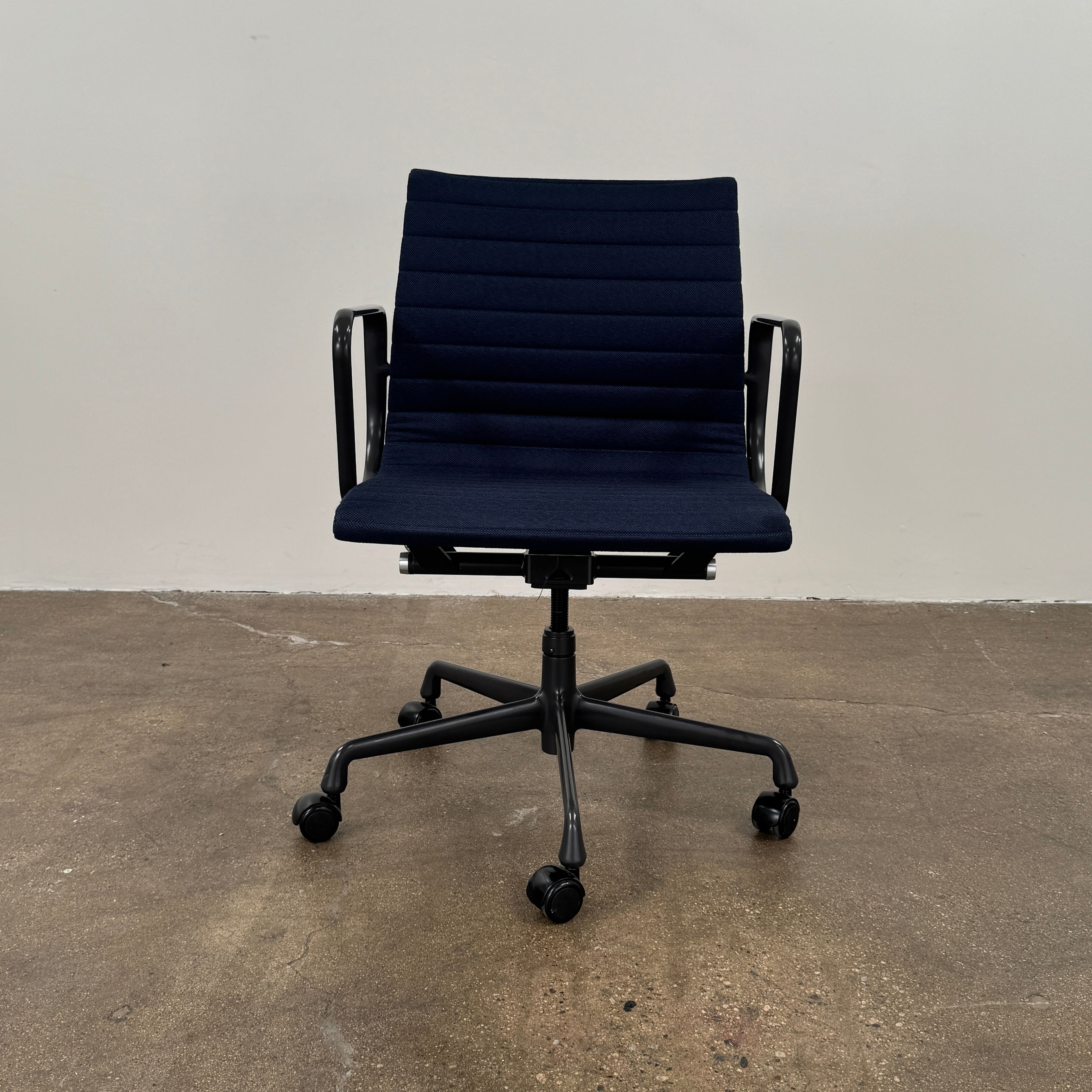 The Herman Miller Aluminum Group Office Chair in Pebble Fabric, by Herman Miller, features an ergonomic design with metal armrests and a five-wheel black base, pictured on a plain white background.