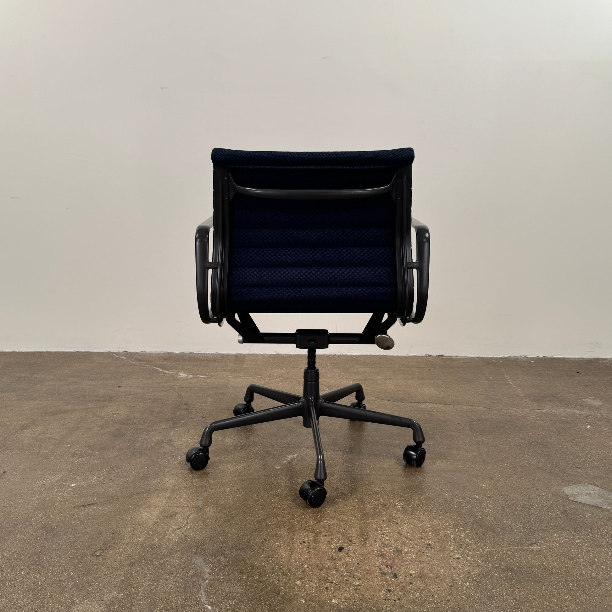 The Herman Miller Aluminum Group Office Chair in Pebble Fabric, by Herman Miller, features an ergonomic design with metal armrests and a five-wheel black base, pictured on a plain white background.