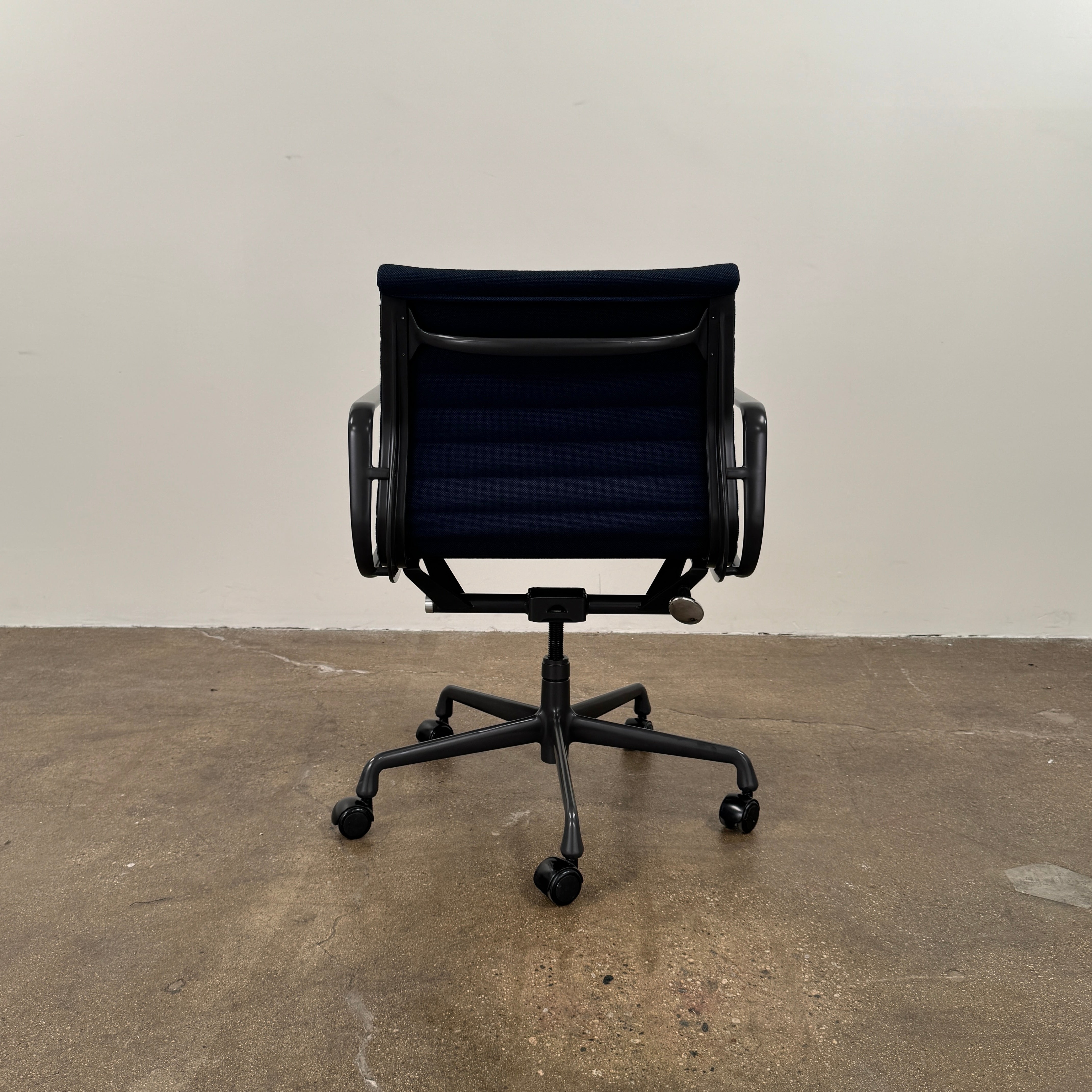 The Herman Miller Aluminum Group Office Chair in Pebble Fabric, by Herman Miller, features an ergonomic design with metal armrests and a five-wheel black base, pictured on a plain white background.