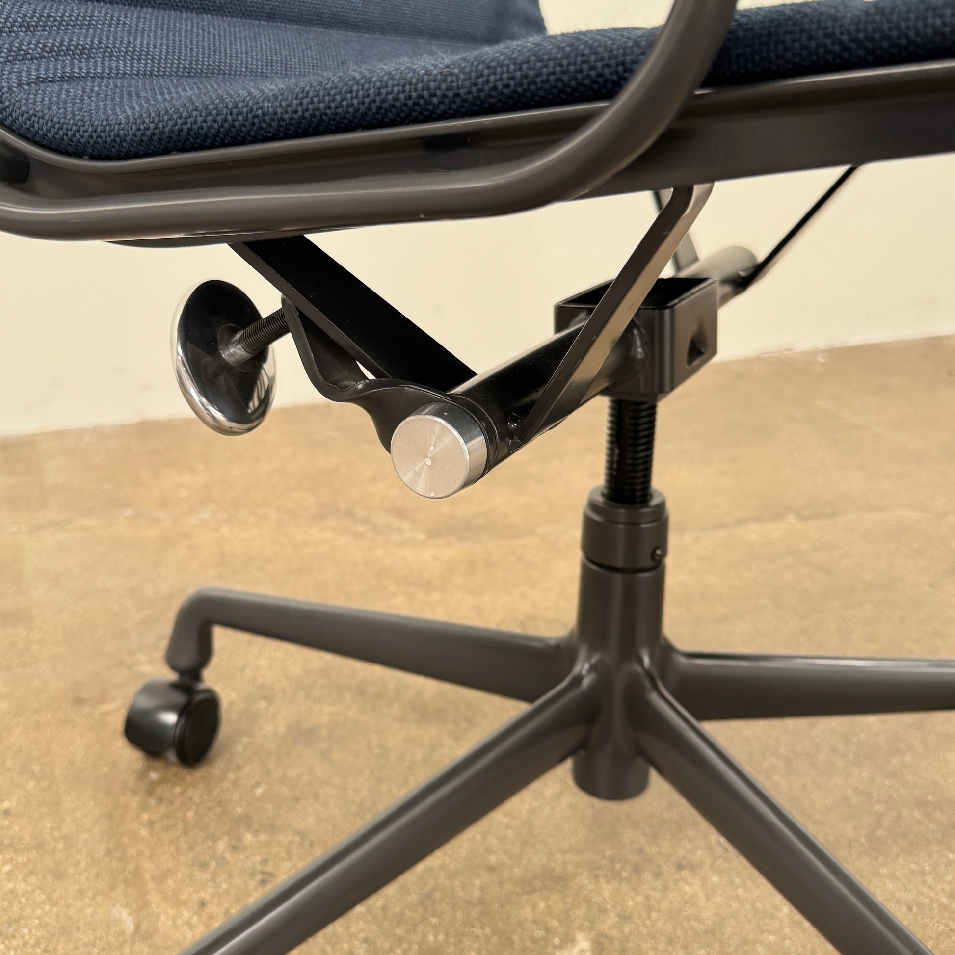 The Herman Miller Aluminum Group Office Chair in Pebble Fabric, by Herman Miller, features an ergonomic design with metal armrests and a five-wheel black base, pictured on a plain white background.