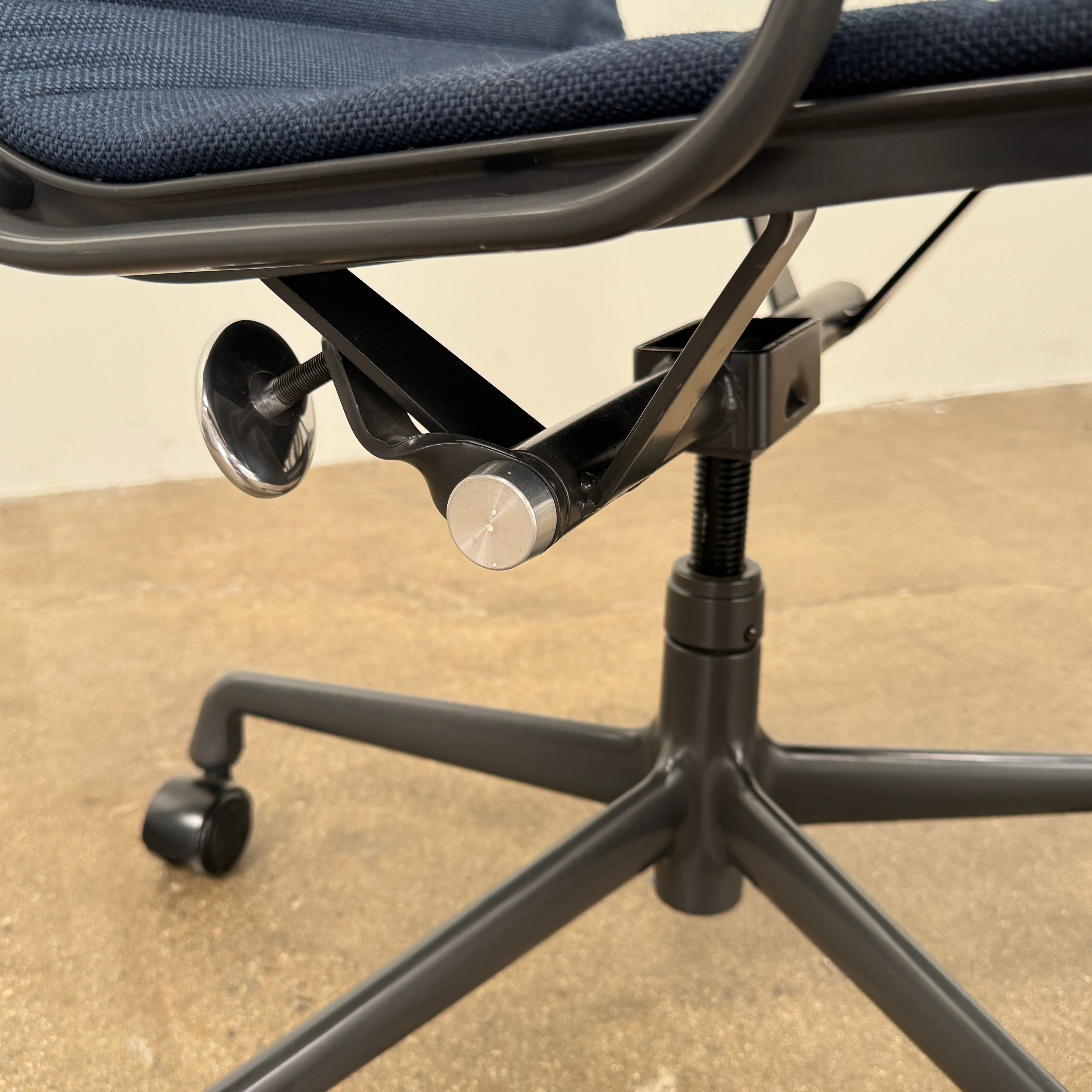 The Herman Miller Aluminum Group Office Chair in Pebble Fabric, by Herman Miller, features an ergonomic design with metal armrests and a five-wheel black base, pictured on a plain white background.