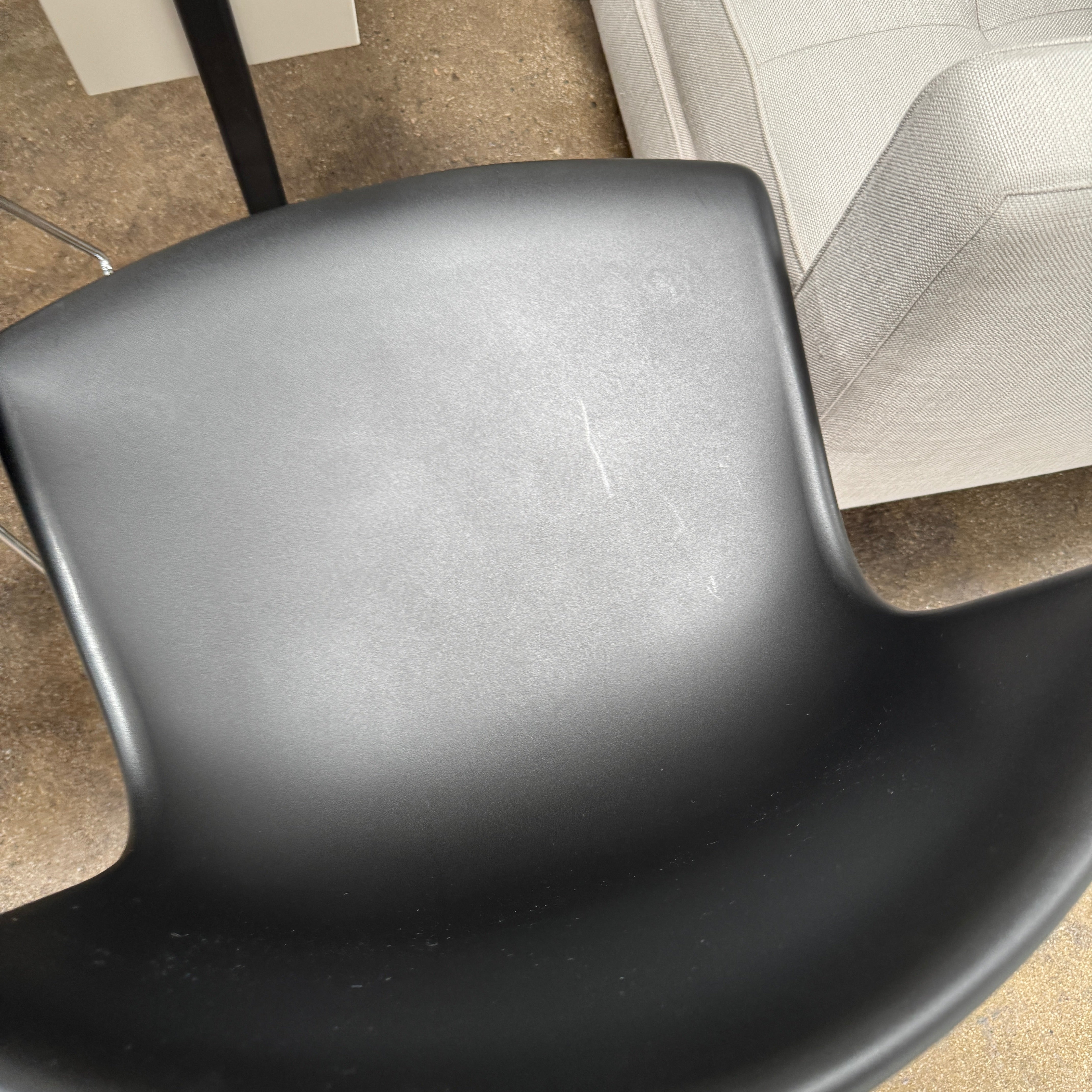 Eight Knoll Bertoia Molded Shell Chairs by Knoll, featuring black plastic seats and metal legs, are arranged in two rows on a white background, showcasing the sleek, timeless silhouette inspired by mid-century design.
