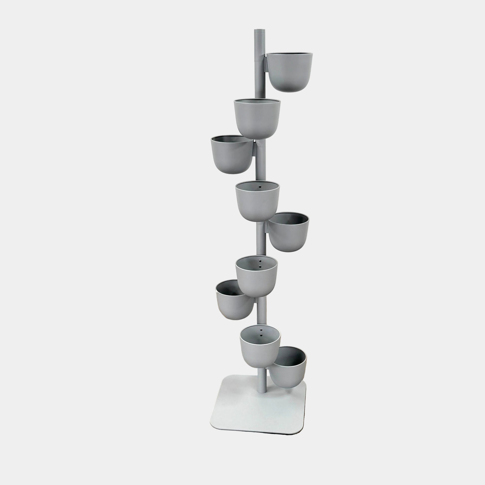 The DWR Story Planter by DWR is a vertical metal plant stand featuring eight gray round pots arranged in a staggered pattern along a single pole with a square base, making it an ideal decorative planter for fans of vertical gardening.
