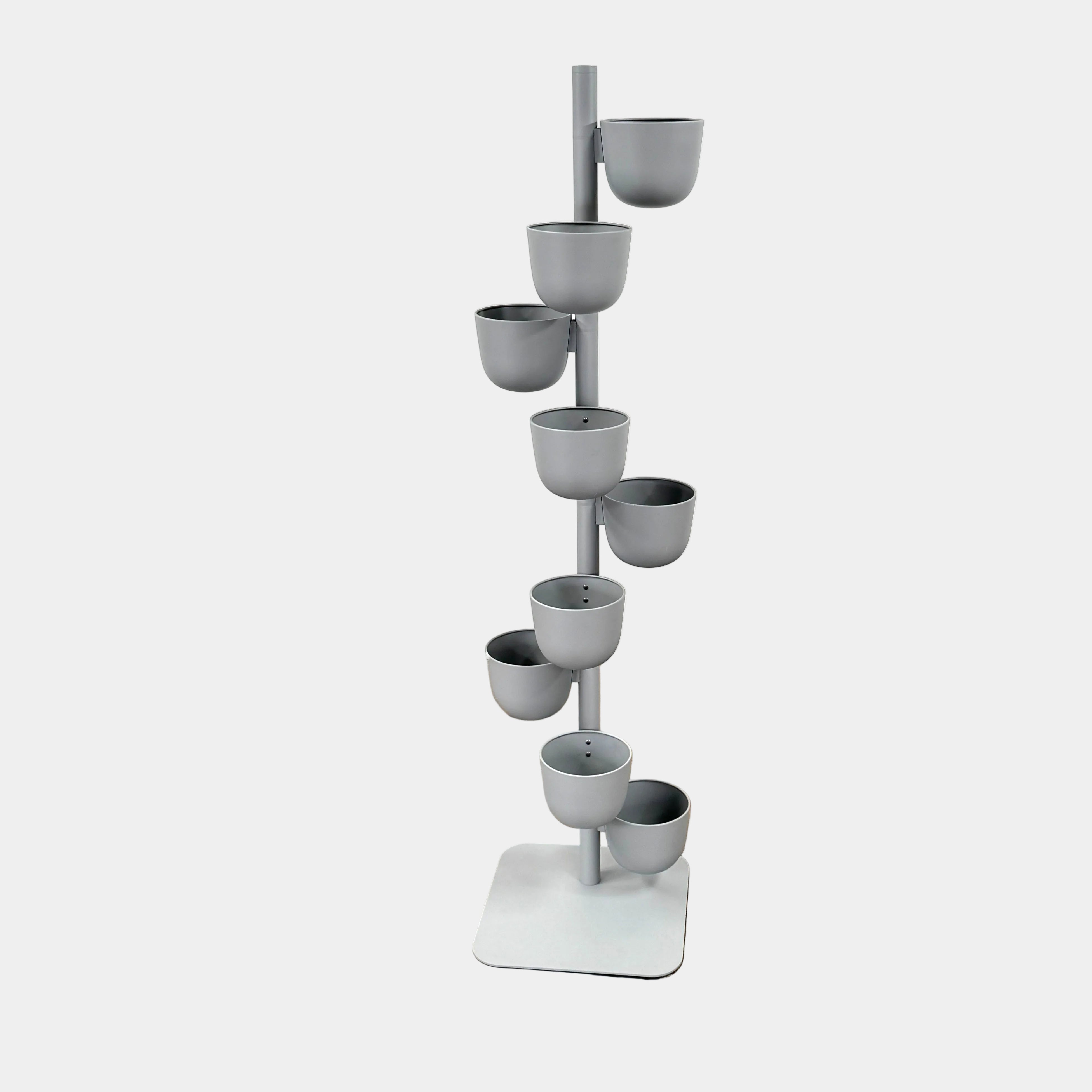 The DWR Story Planter by DWR is a vertical metal plant stand featuring eight gray round pots arranged in a staggered pattern along a single pole with a square base, making it an ideal decorative planter for fans of vertical gardening.
