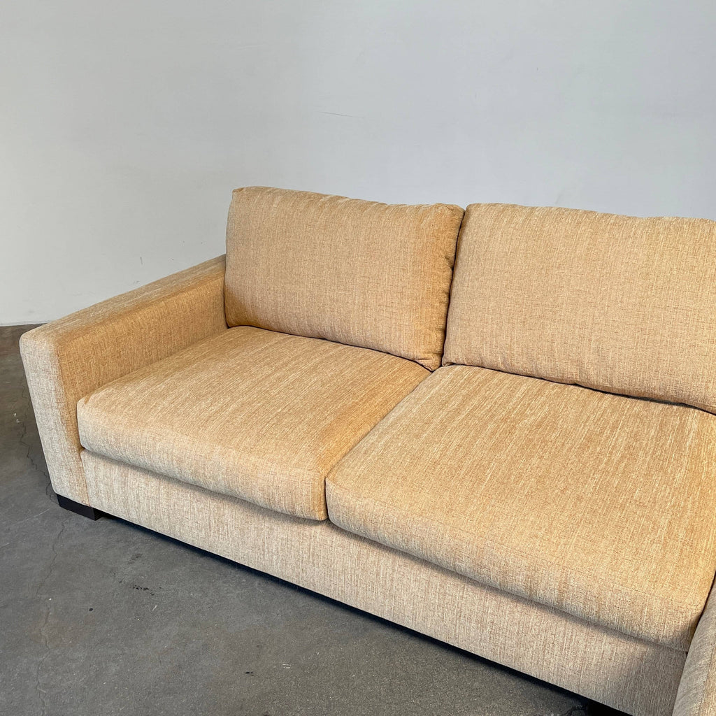 An Archetype Design Development structured sectional sofa with a pillow on it.