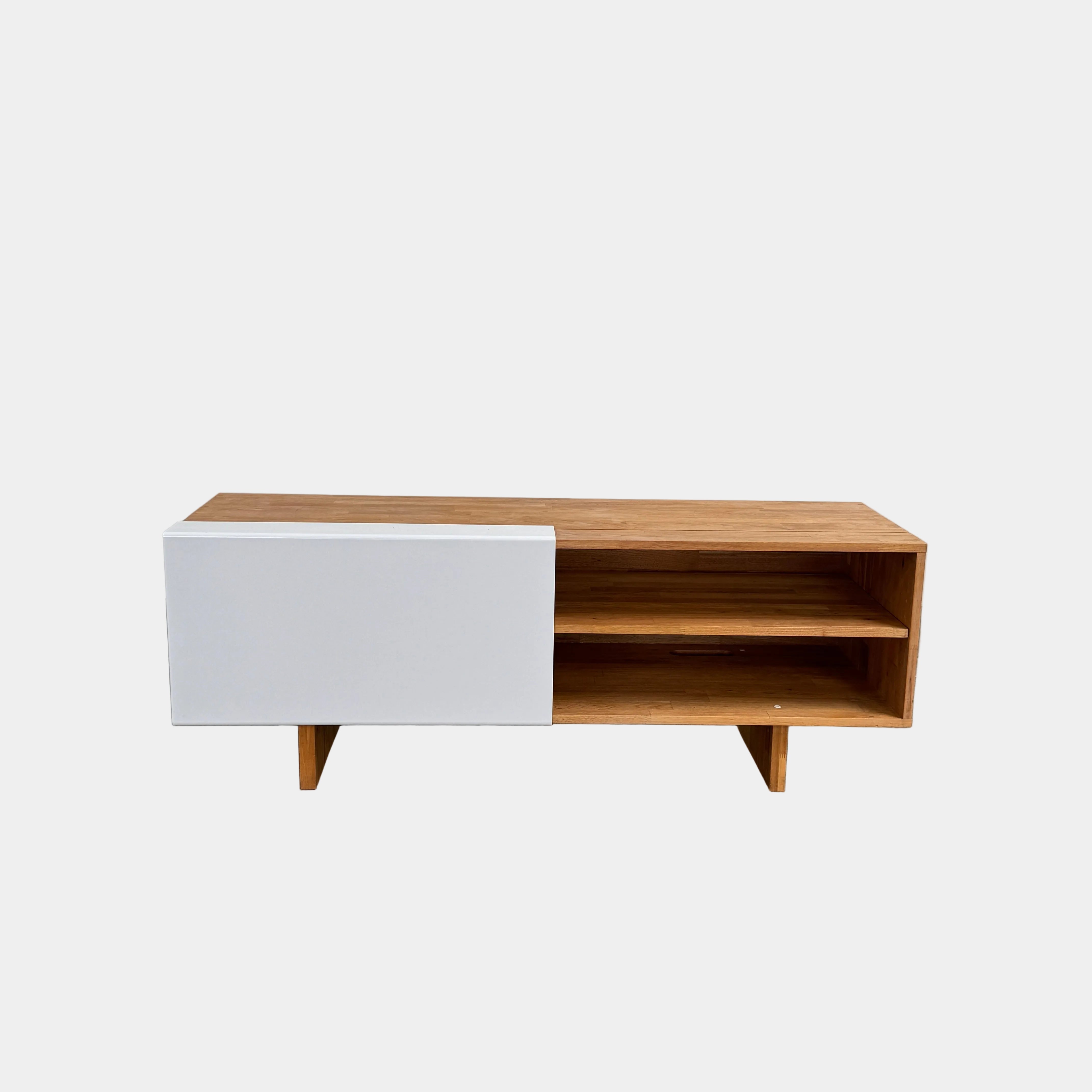 The Mash Studios LAXseries Media Console by Mash Studios is a modern wooden TV stand crafted from solid English walnut, featuring a sleek white sliding door, two open shelves with wire management for convenience, and distinctive angled legs, shown against a plain white background.