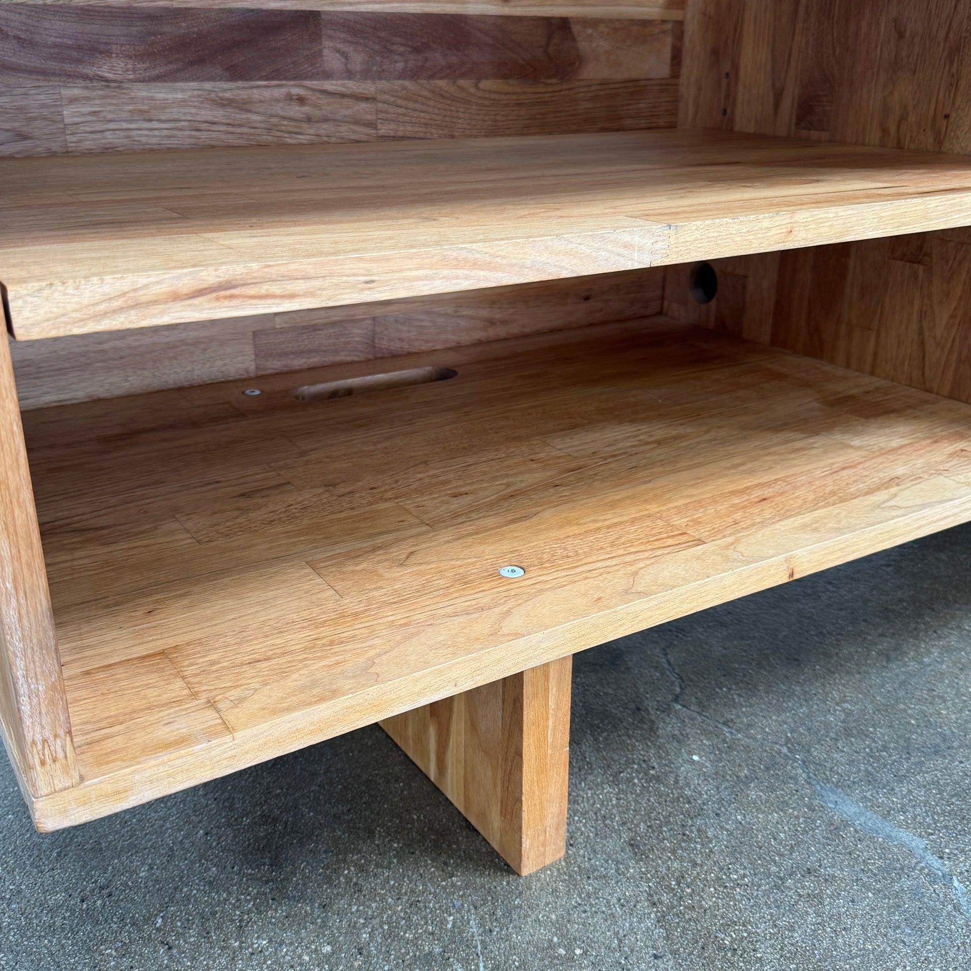 The Mash Studios LAXseries Media Console by Mash Studios is a modern wooden TV stand crafted from solid English walnut, featuring a sleek white sliding door, two open shelves with wire management for convenience, and distinctive angled legs, shown against a plain white background.