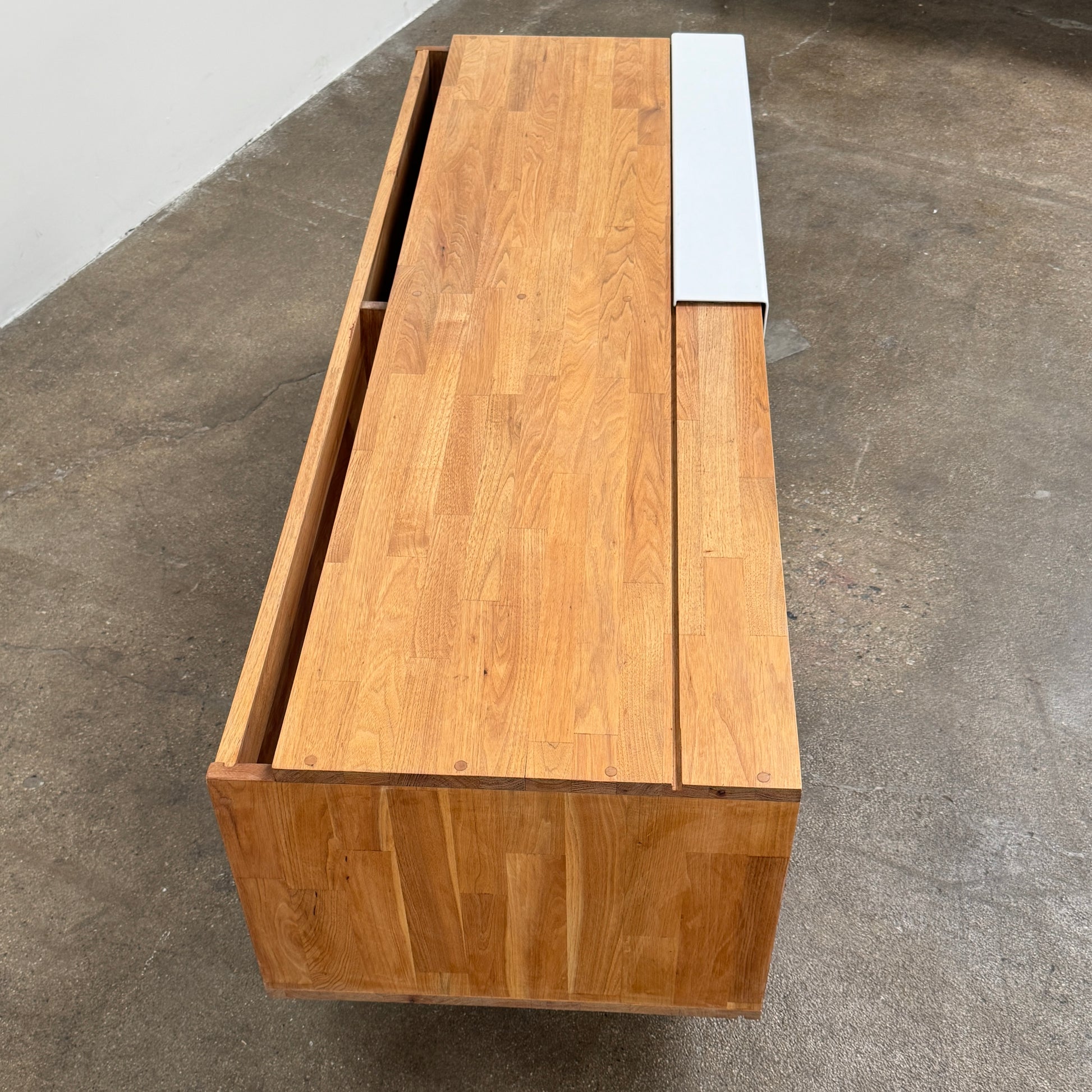 The Mash Studios LAXseries Media Console by Mash Studios is a modern wooden TV stand crafted from solid English walnut, featuring a sleek white sliding door, two open shelves with wire management for convenience, and distinctive angled legs, shown against a plain white background.