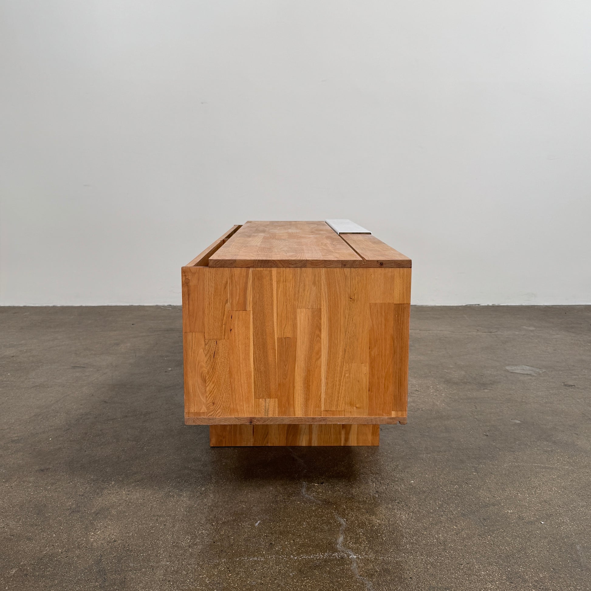 The Mash Studios LAXseries Media Console by Mash Studios is a modern wooden TV stand crafted from solid English walnut, featuring a sleek white sliding door, two open shelves with wire management for convenience, and distinctive angled legs, shown against a plain white background.