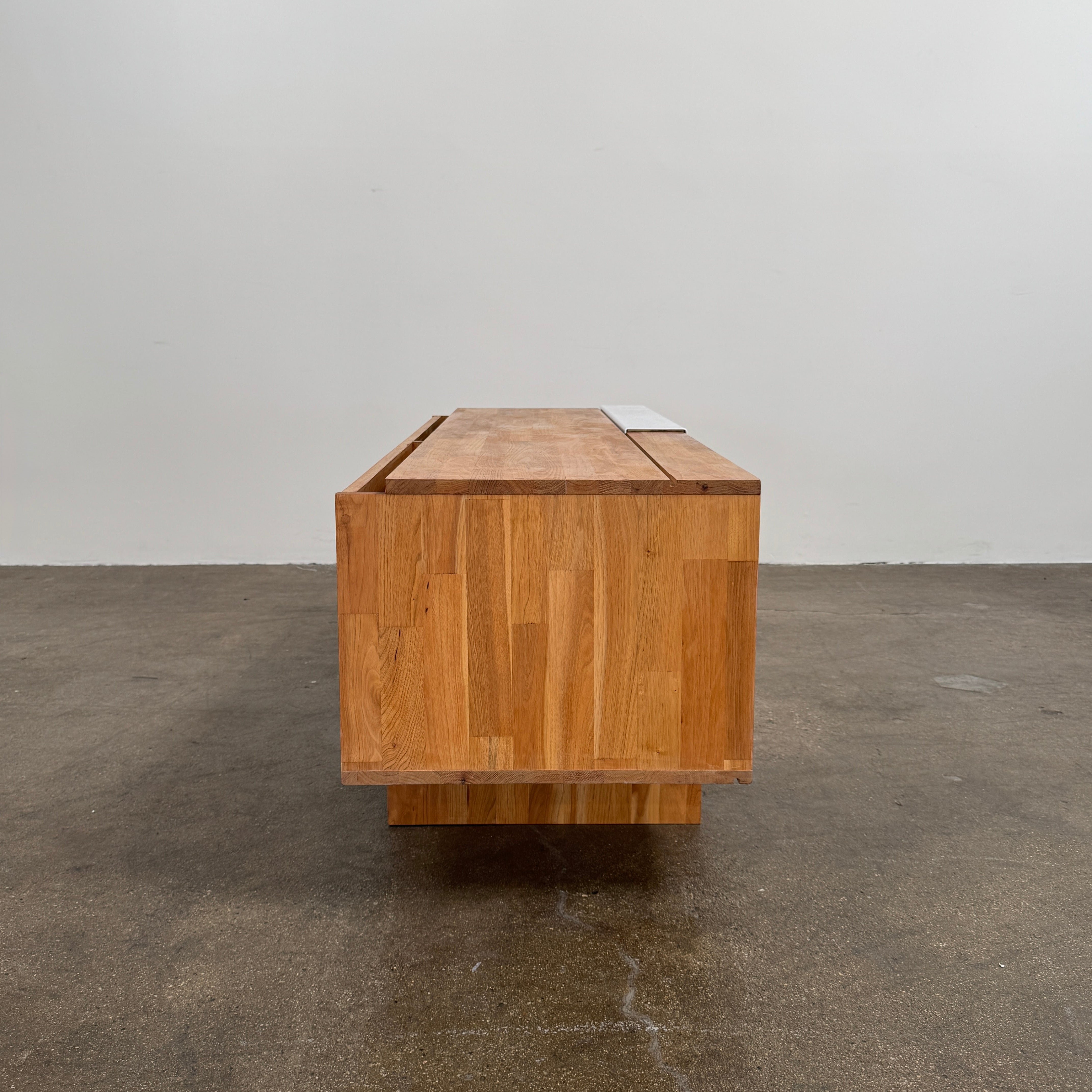 The Mash Studios LAXseries Media Console by Mash Studios is a modern wooden TV stand crafted from solid English walnut, featuring a sleek white sliding door, two open shelves with wire management for convenience, and distinctive angled legs, shown against a plain white background.