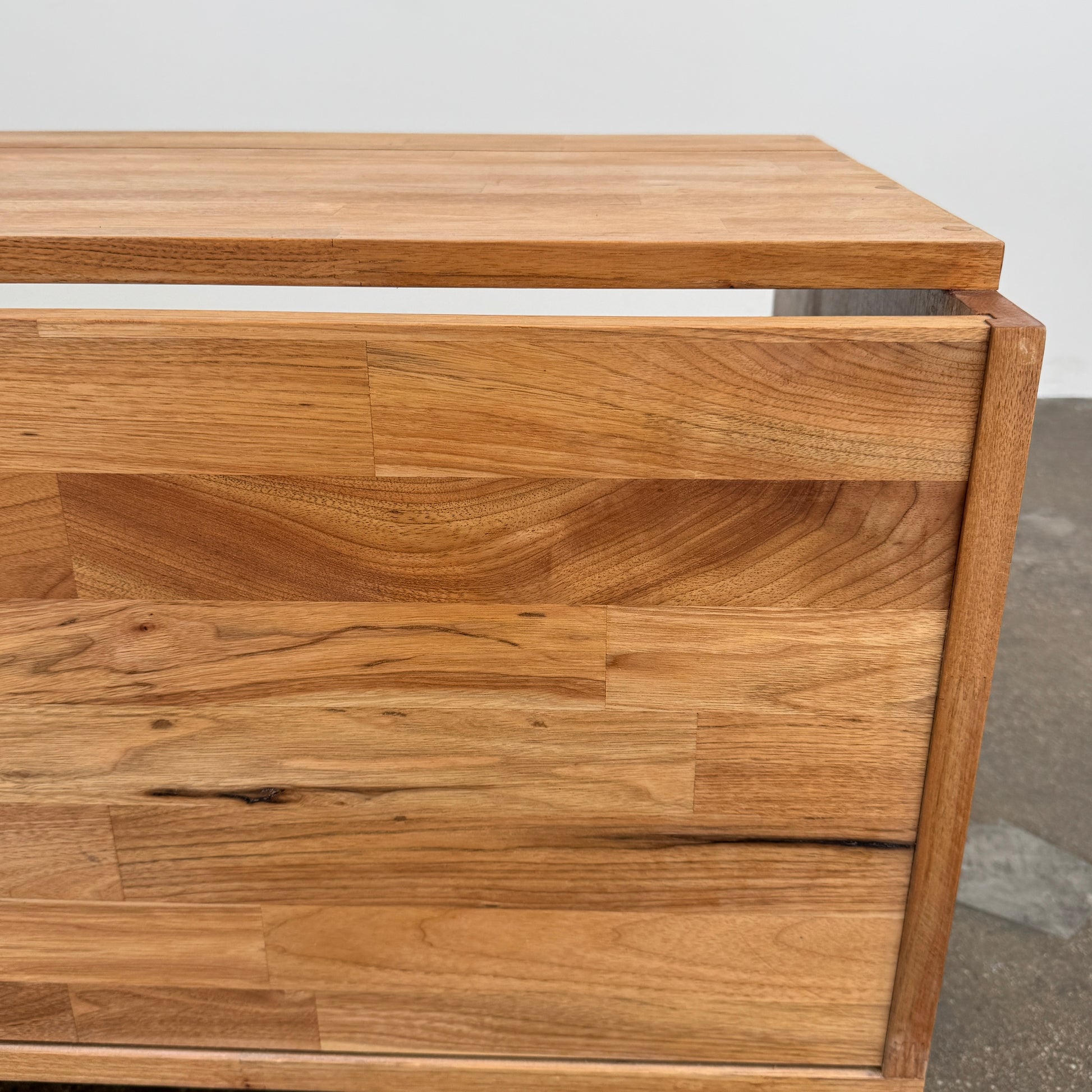 The Mash Studios LAXseries Media Console by Mash Studios is a modern wooden TV stand crafted from solid English walnut, featuring a sleek white sliding door, two open shelves with wire management for convenience, and distinctive angled legs, shown against a plain white background.