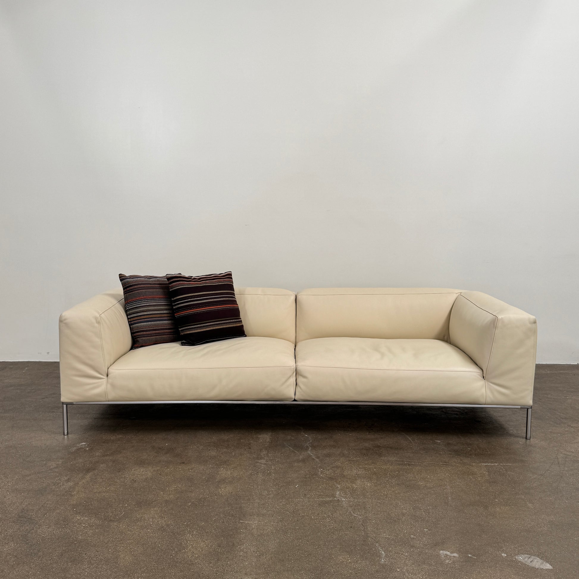 A beige B&B Italia Frank Sofa by B&B Italia, featuring metal legs and a minimalist modern design, is set against a plain white background.